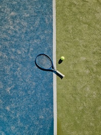 A tennis racket and ball on the court.
