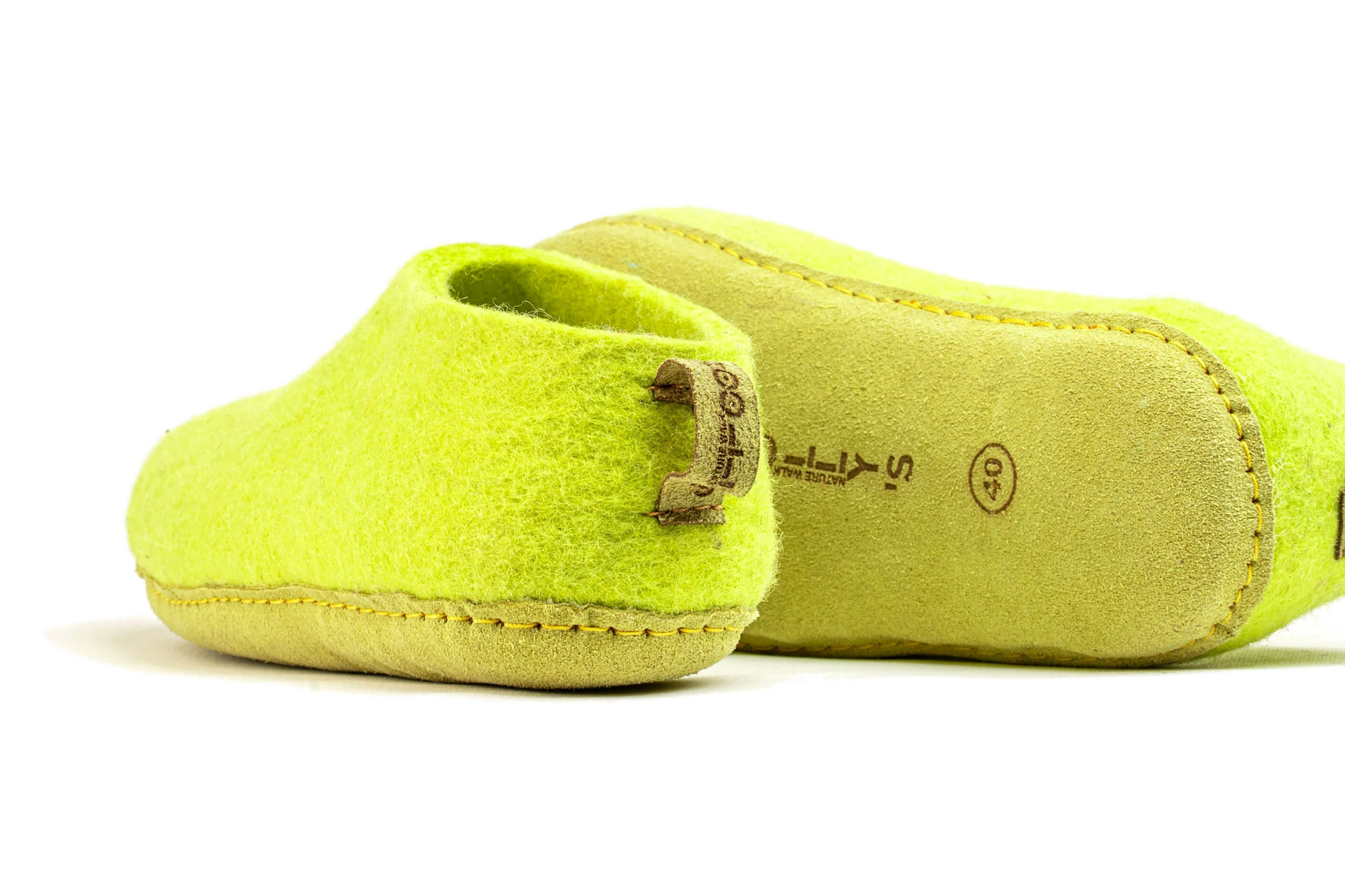 Lime-green slippers are resting on a white surface., 