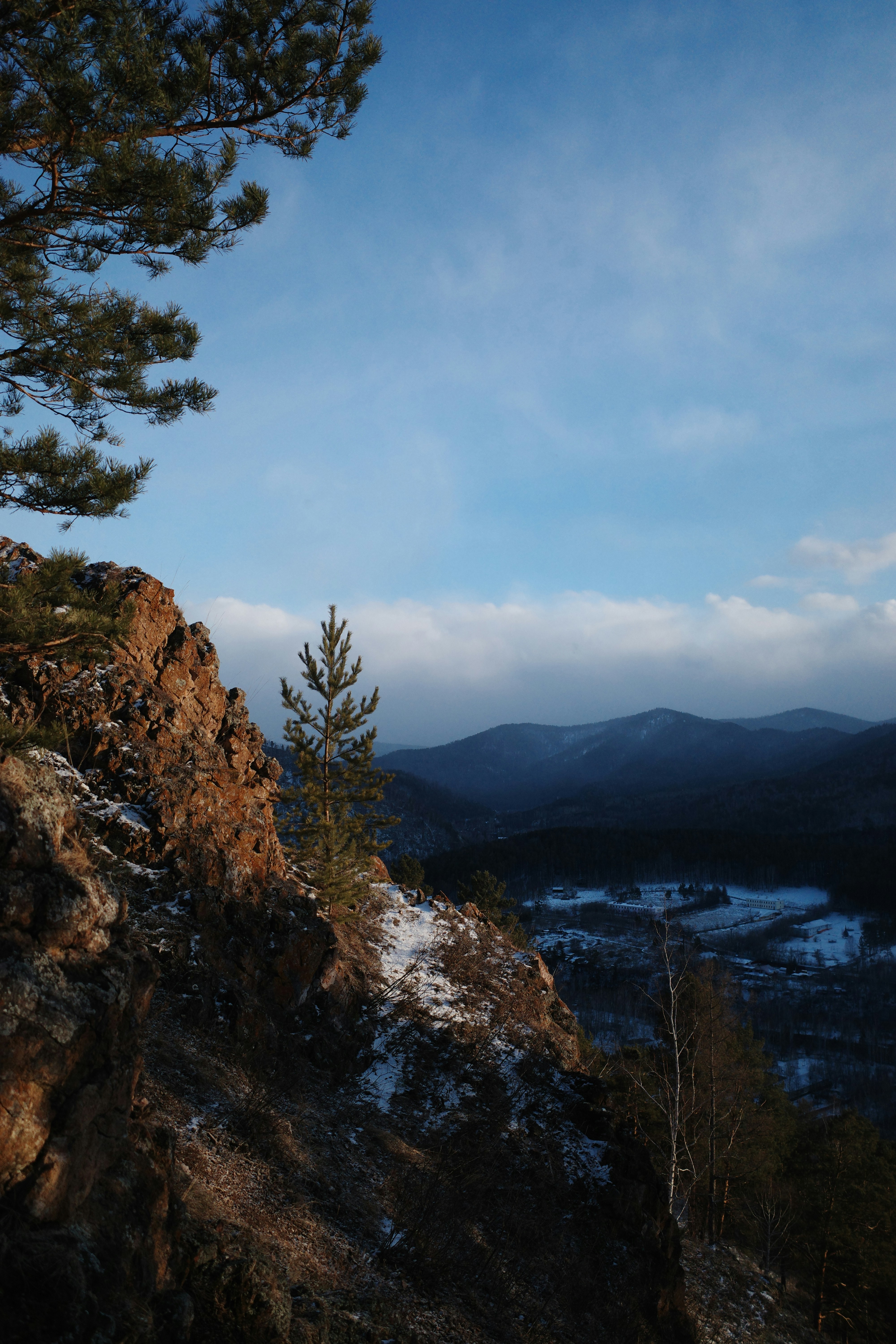 Rocky cliff overlooks a mountainous landscape.