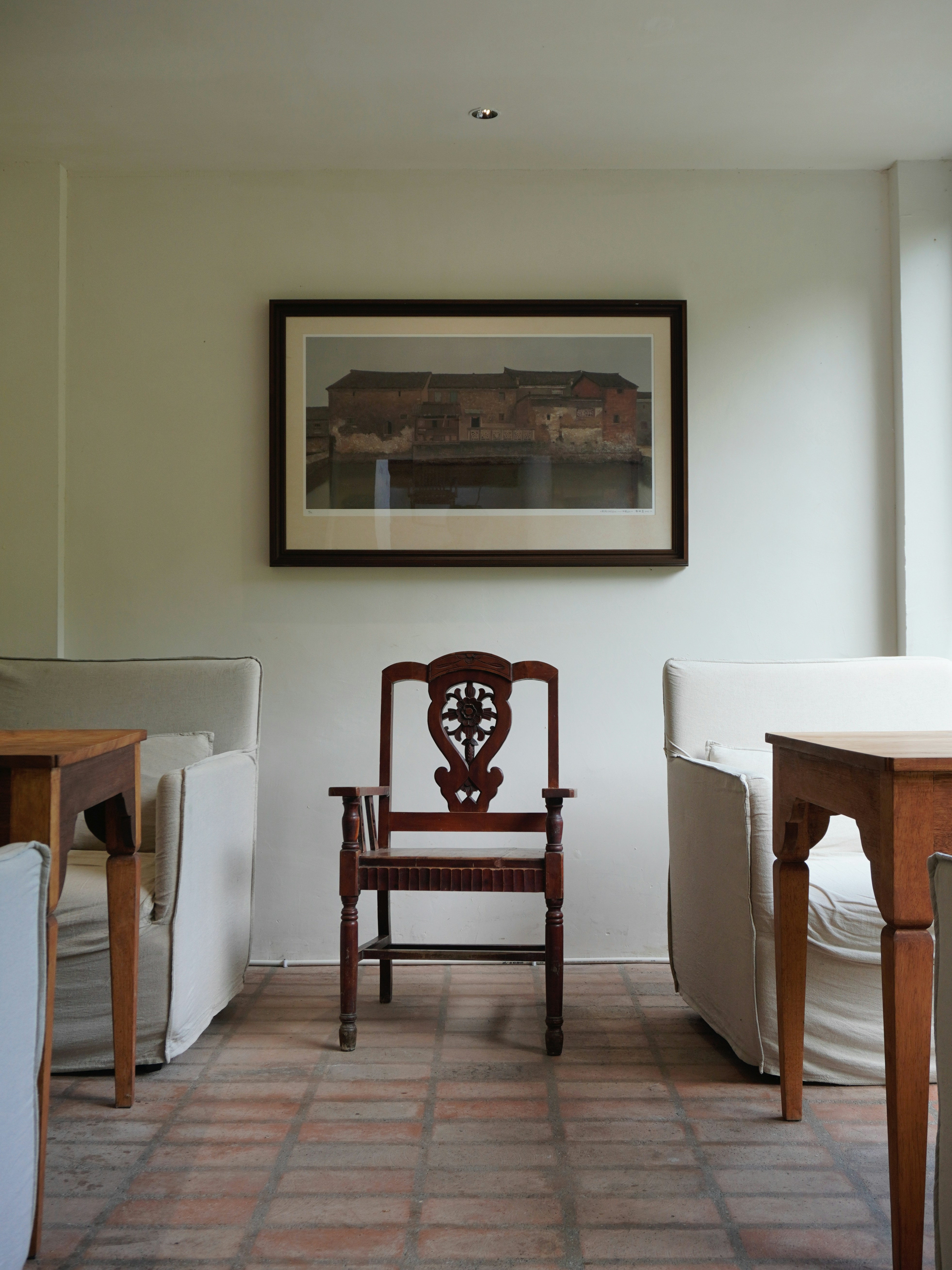 An antique chair sits between sofas.