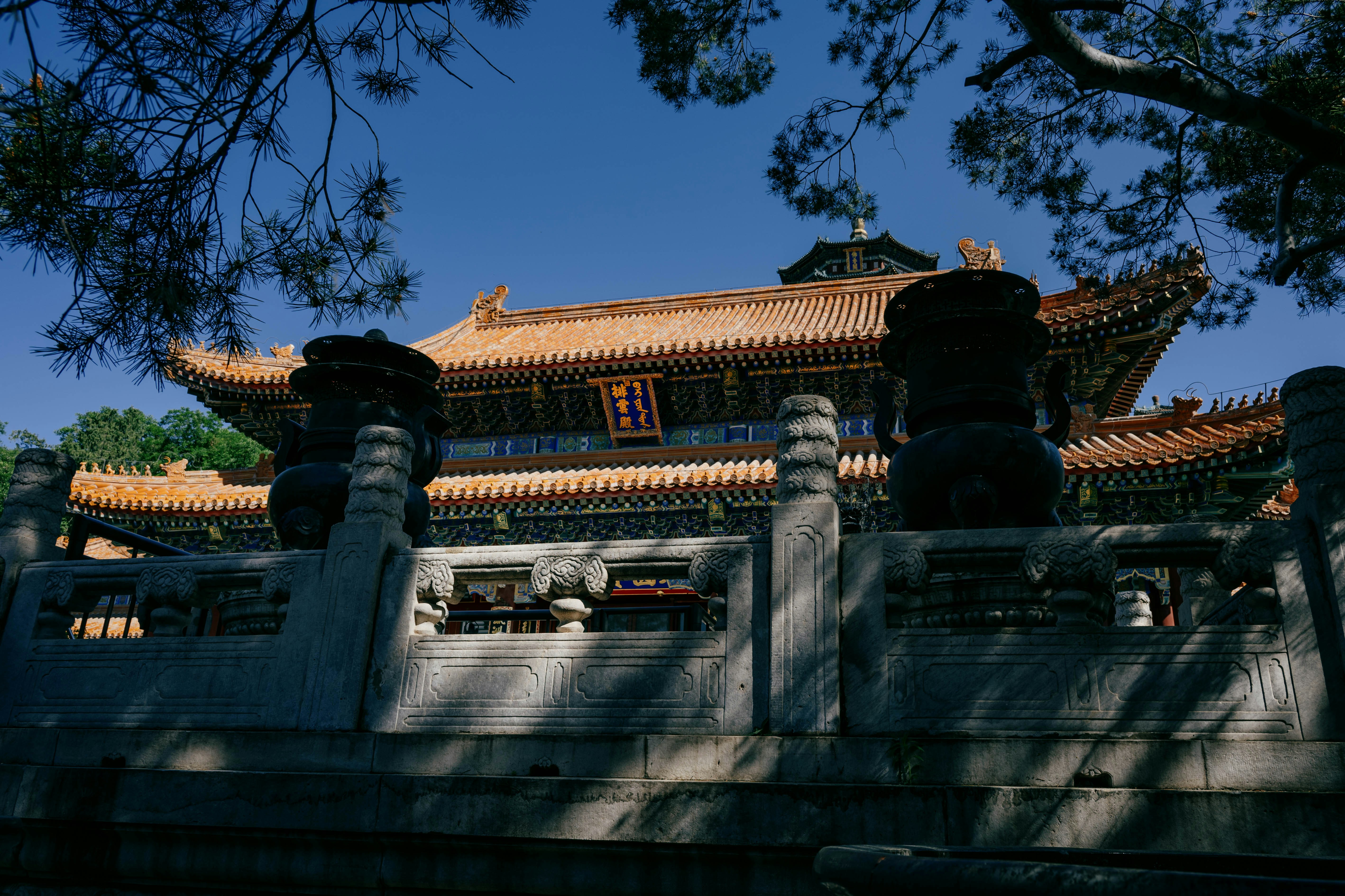 Un tempio decorato è incorniciato da fogliame e da una recinzione.