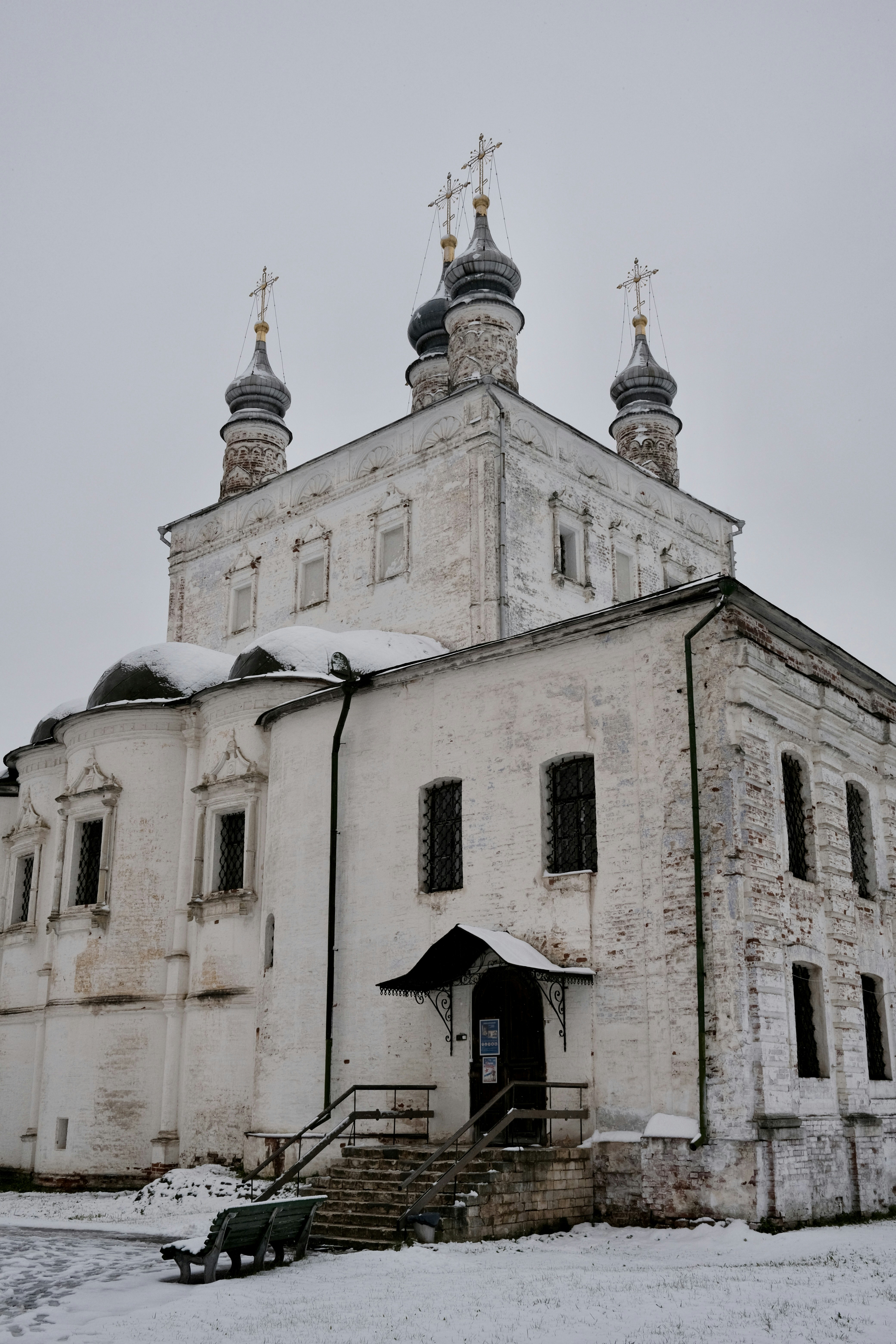 An old, white church sits in the snow.