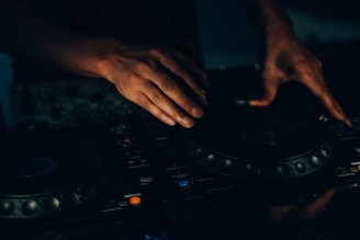 Dj manipulating the music console with his hands.