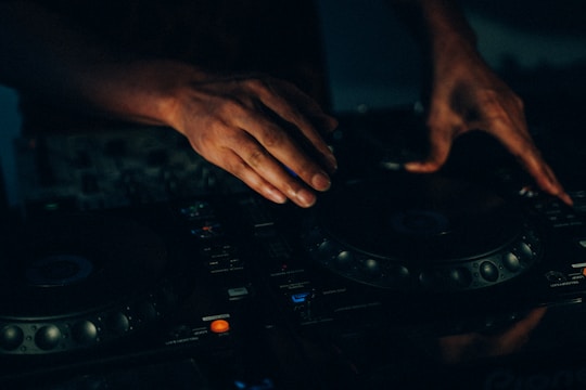 Dj manipulating the music console with his hands.