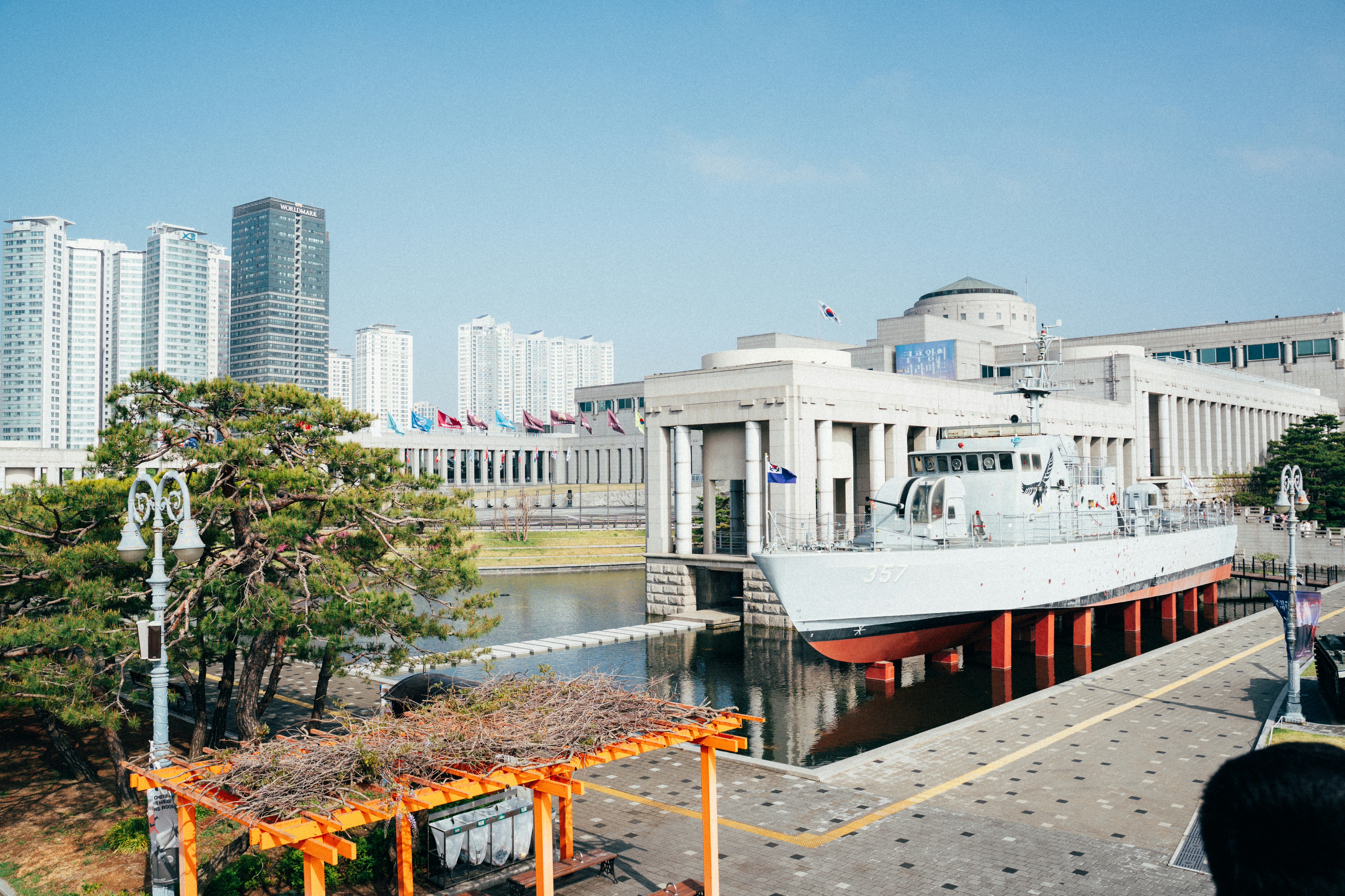 A ship sits in front of a large building.