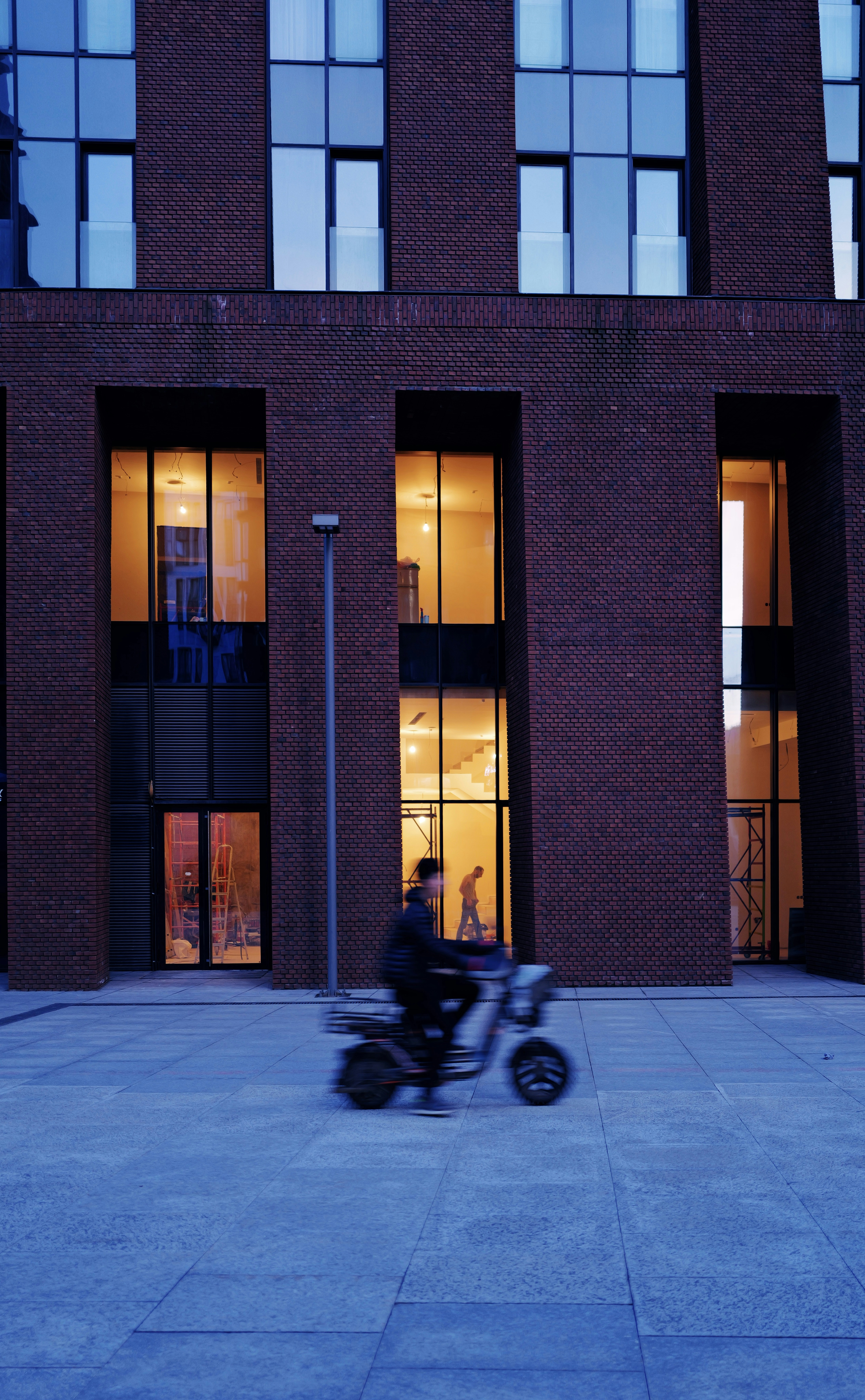 A scooter drives in front of a building.