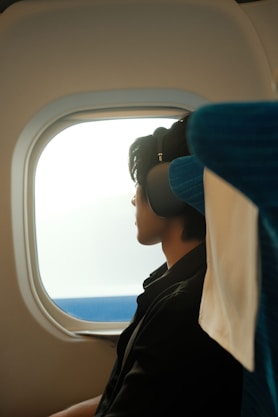 Man looks out of an airplane window.