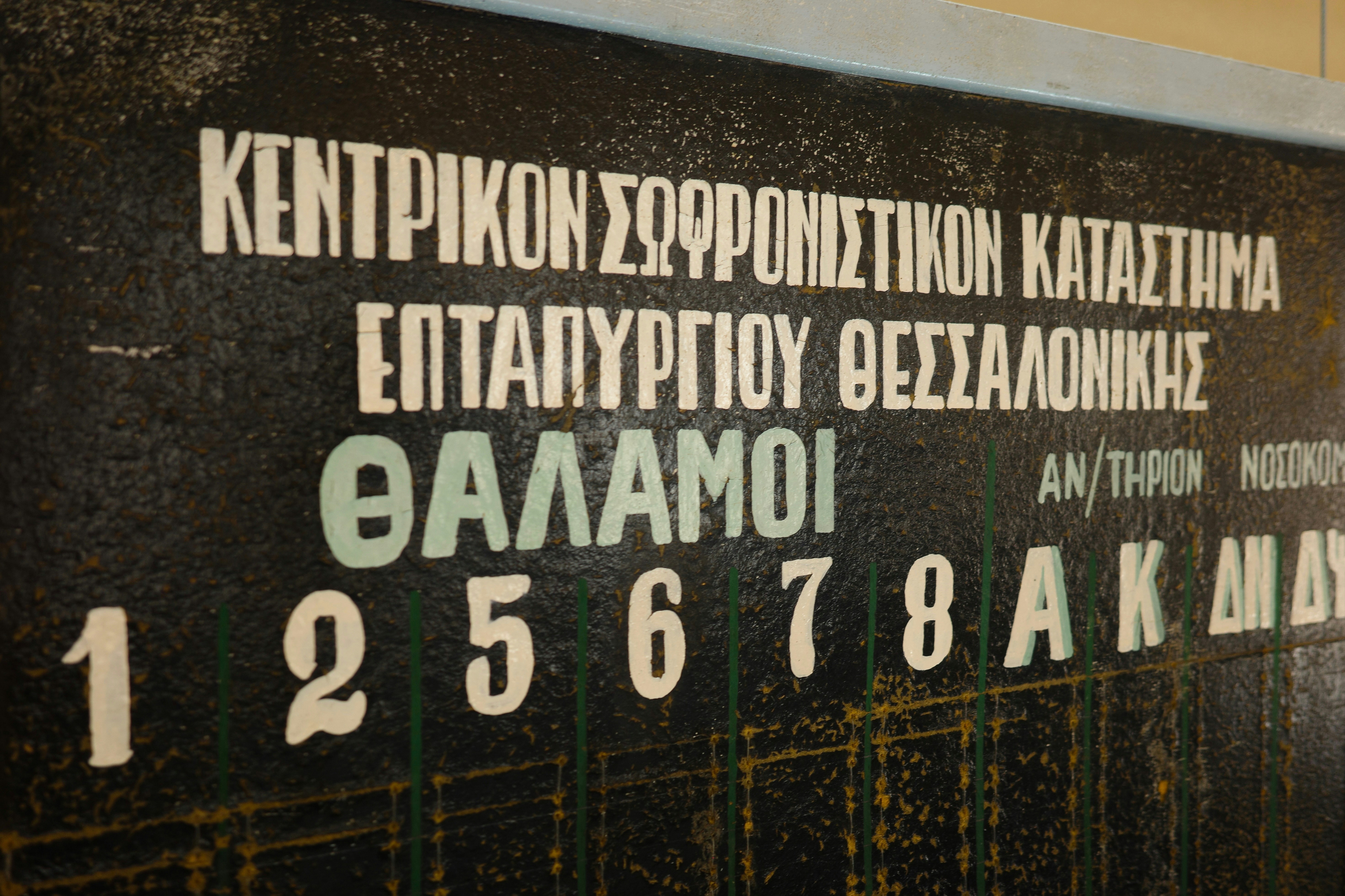 Greek text and numbers are visible on a blackboard.