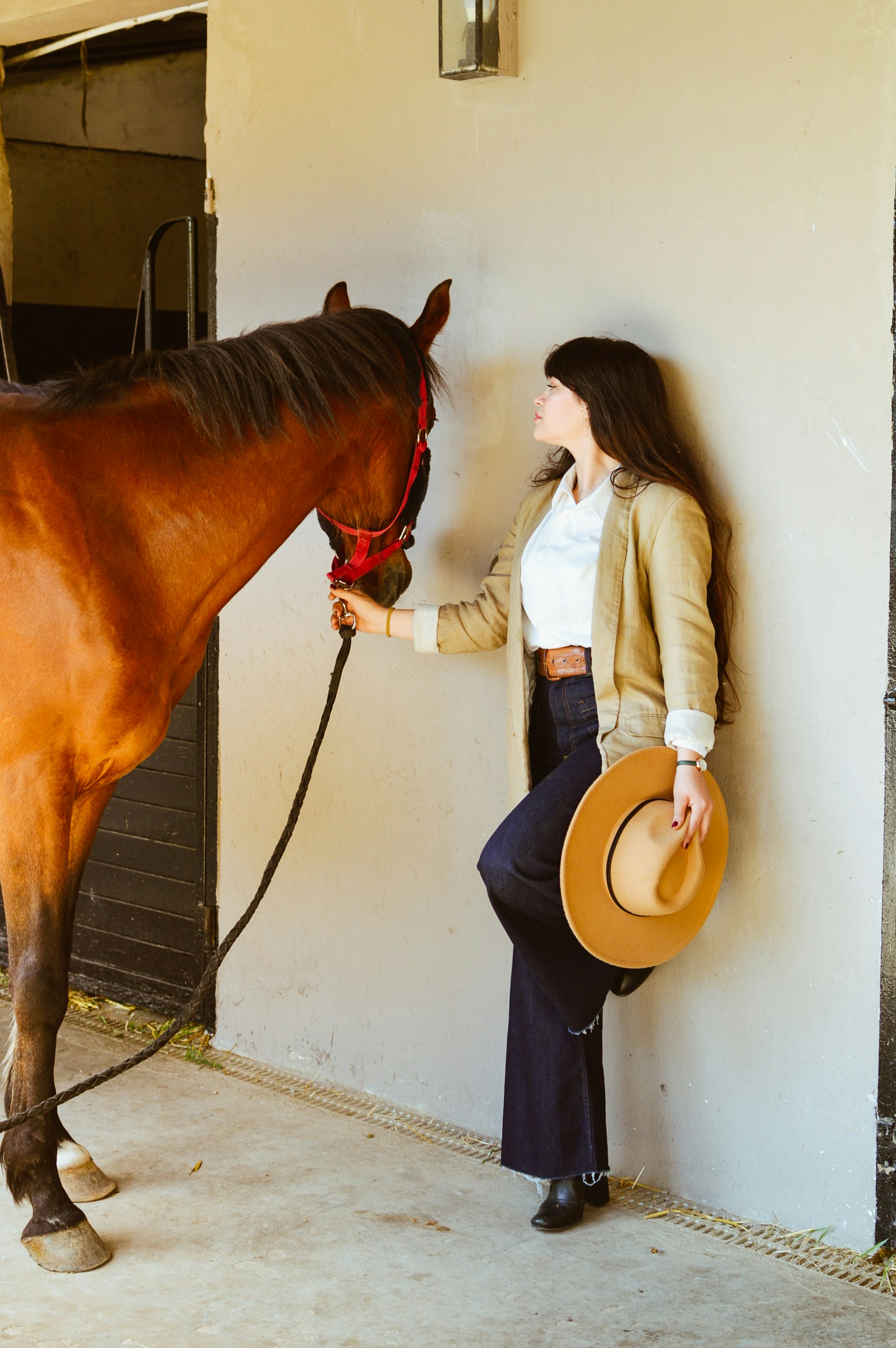 Uma mulher posa com um cavalo.