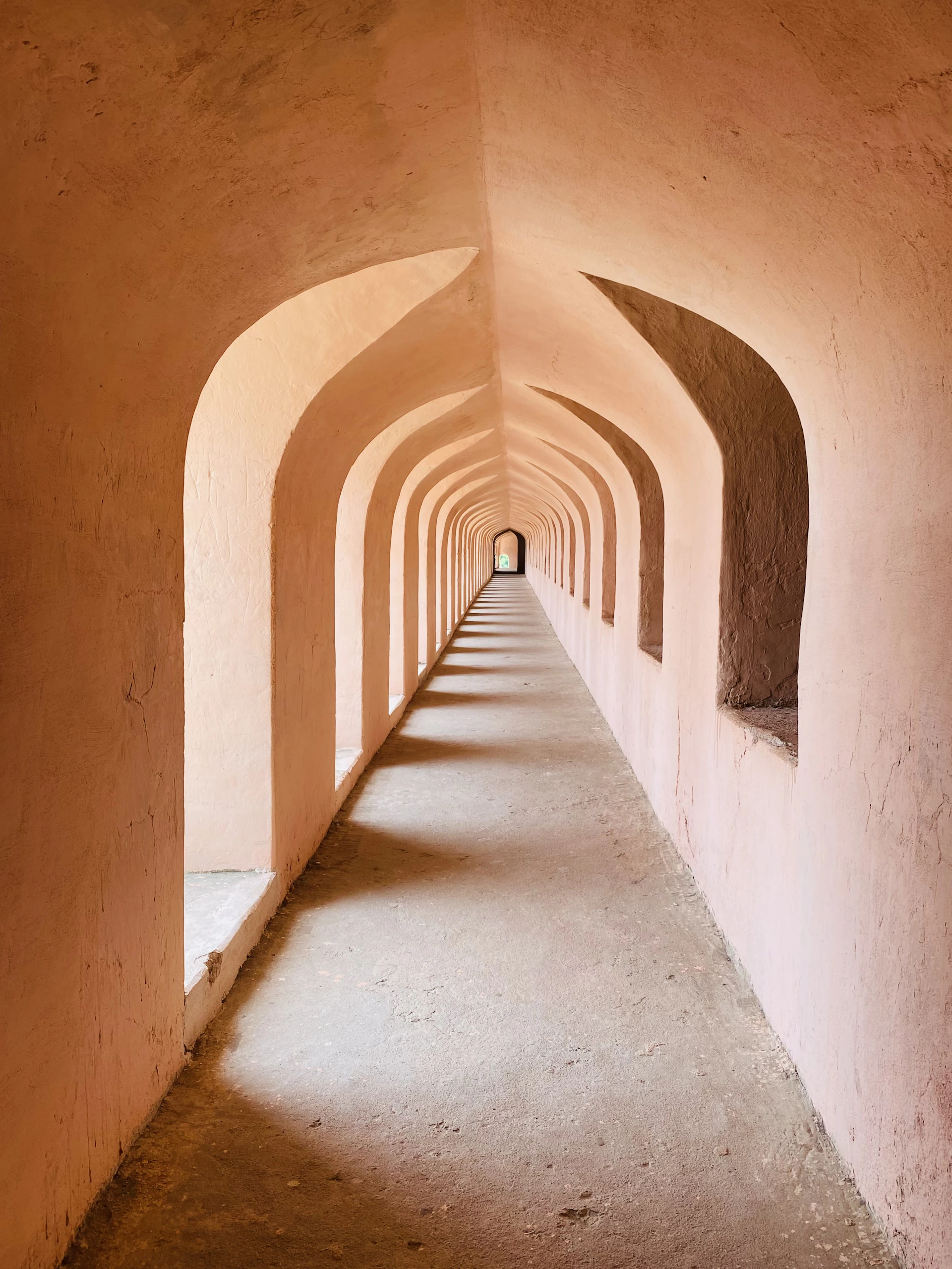 A long, arched corridor with light and shadows.