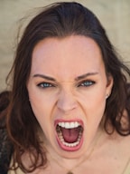 A woman is screaming directly at the camera.