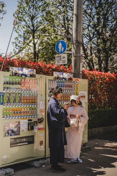 Two people are standing next to a drink vending machine.