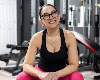 Woman smiles happily in her home gym.
