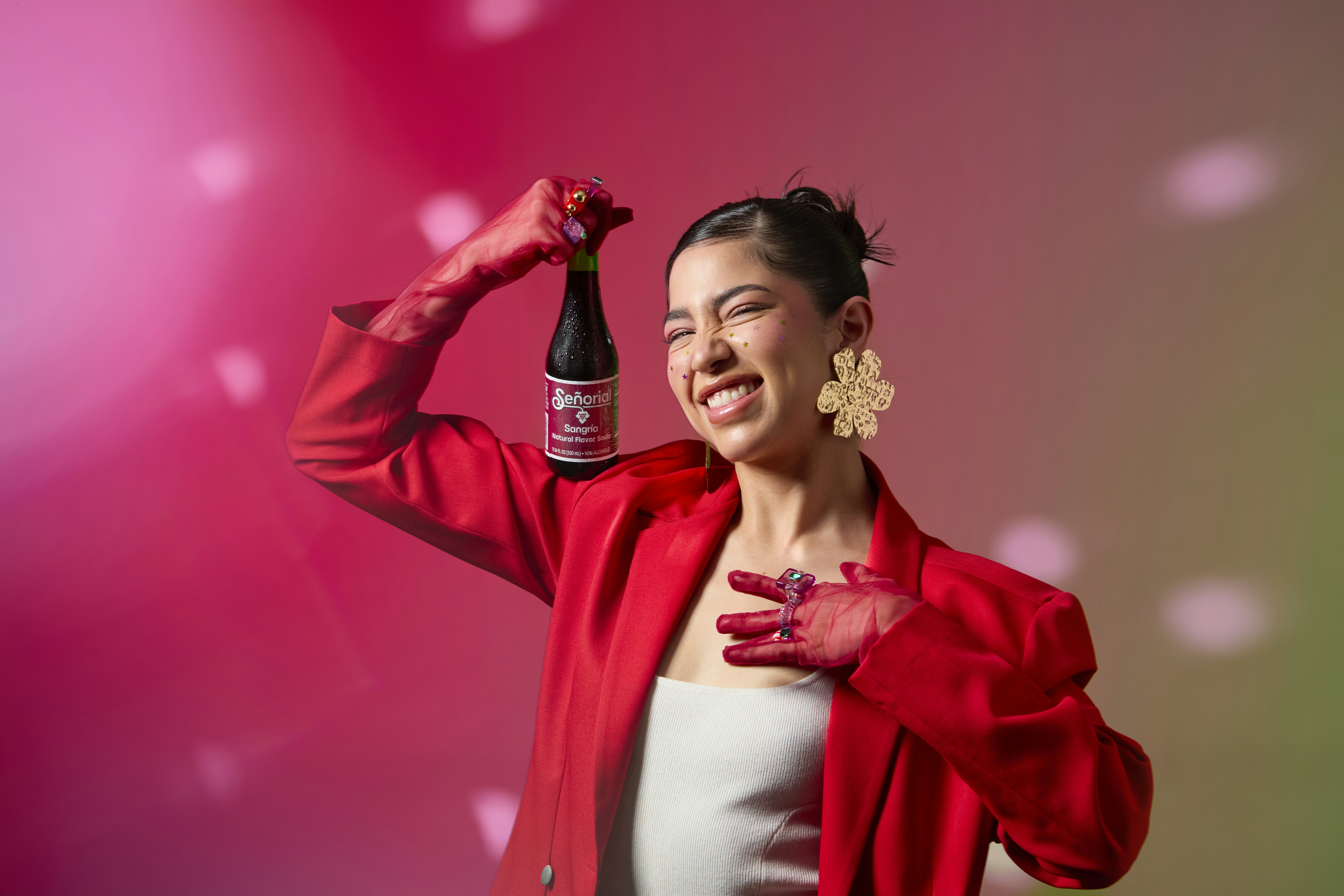 Woman holds a bottle of product with a smile.