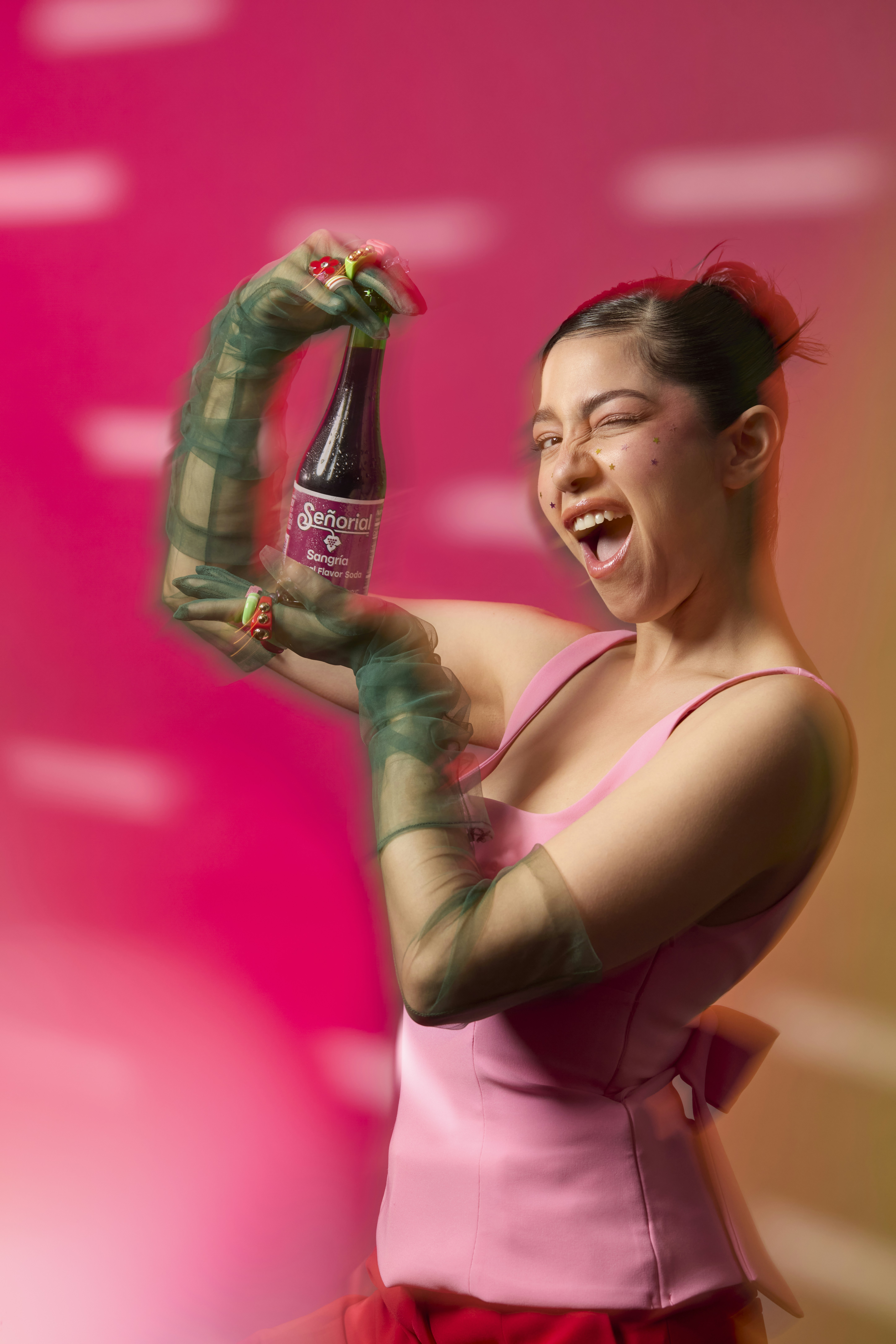 Woman happily shows off a bottle of beverage.