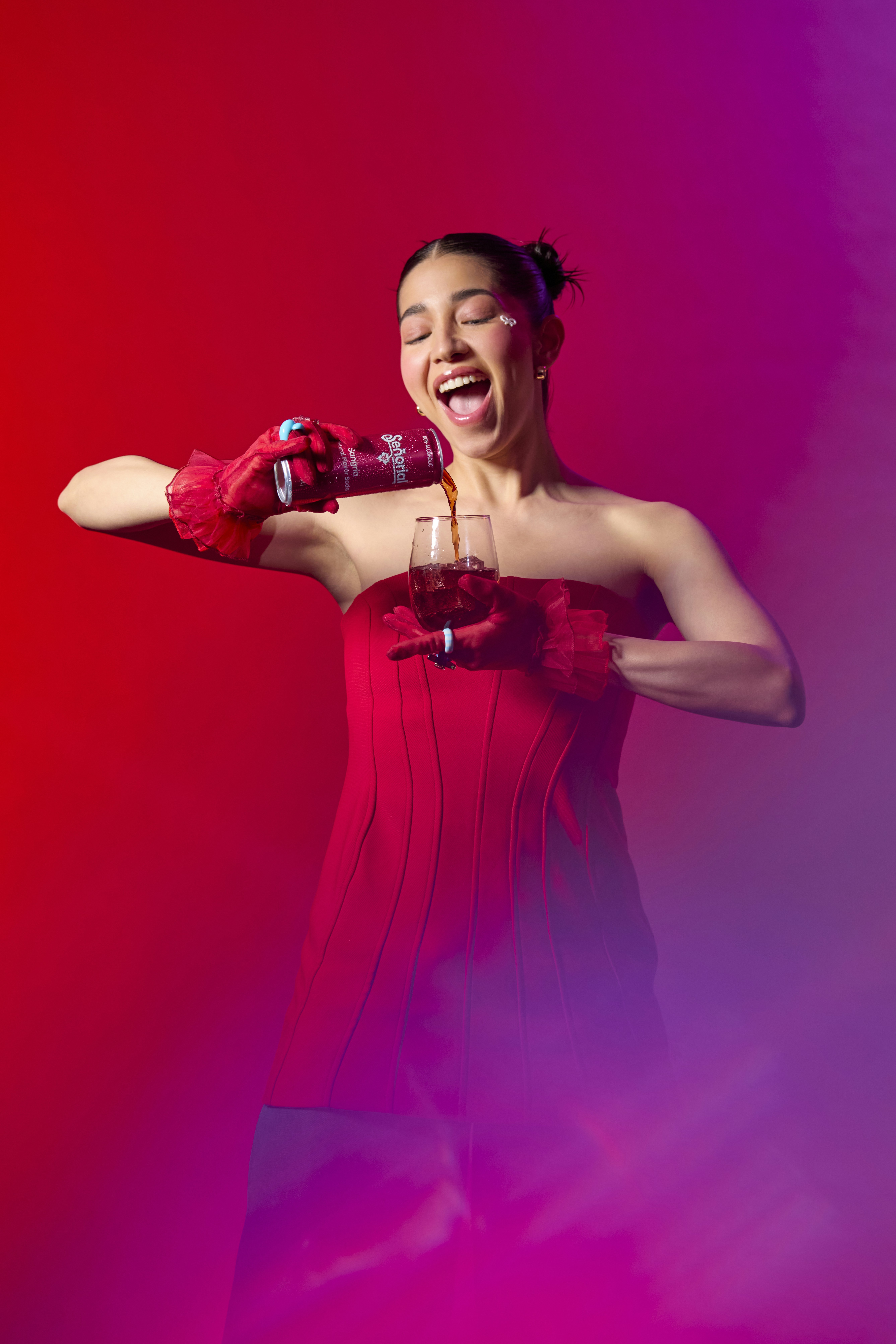 Woman joyfully pours a drink.