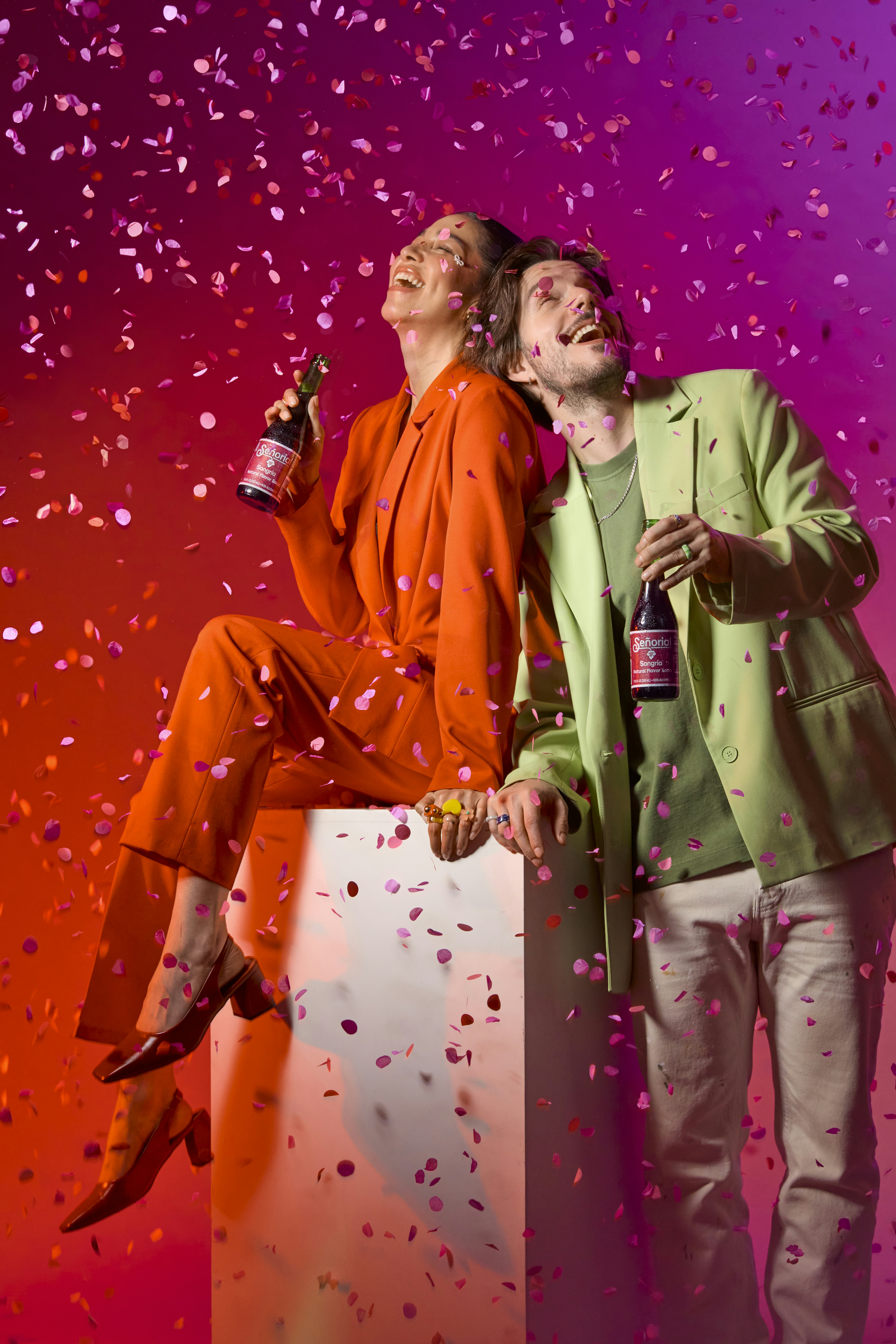 People celebrate with drinks and confetti.