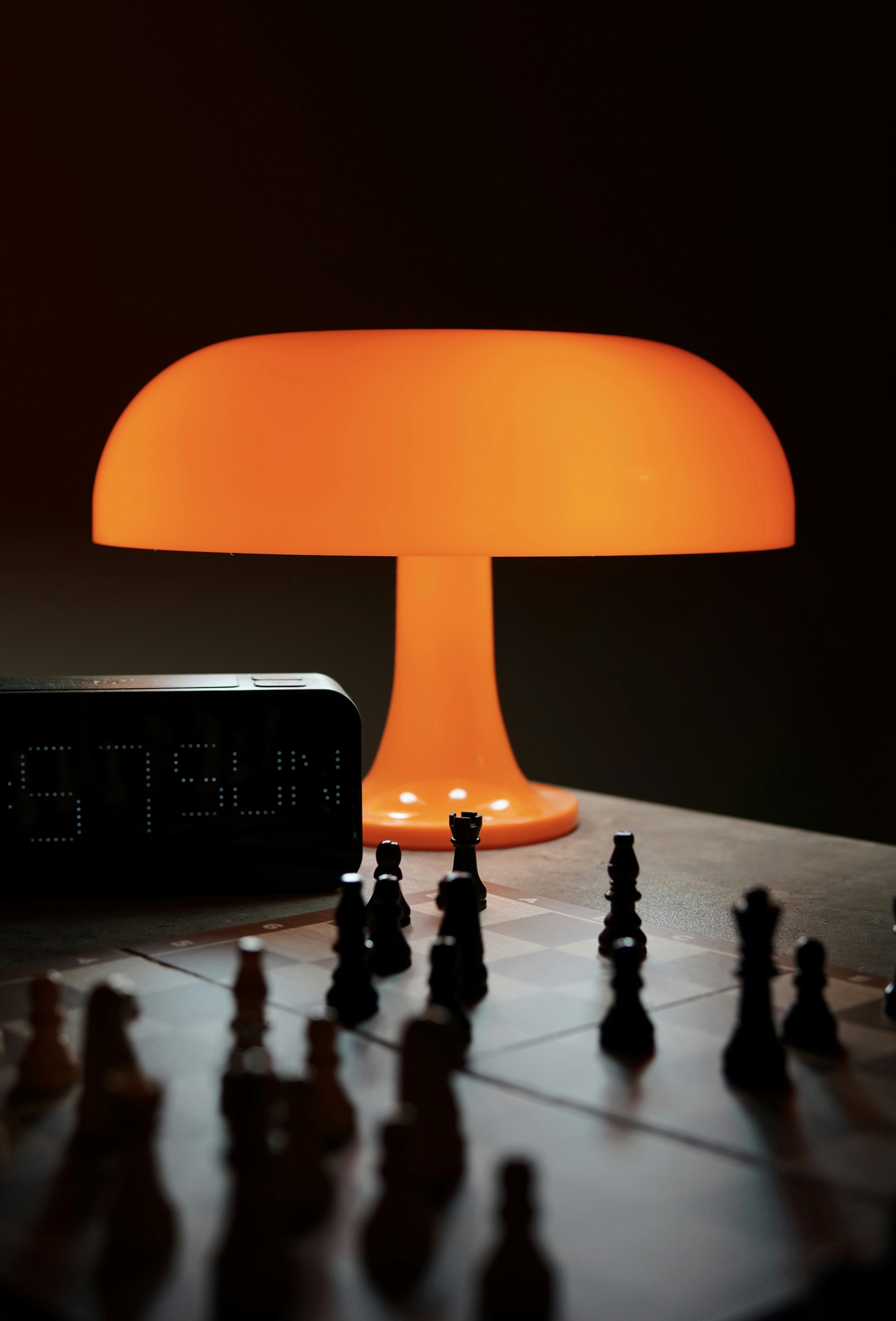 El tablero de ajedrez se coloca debajo de una lámpara naranja.