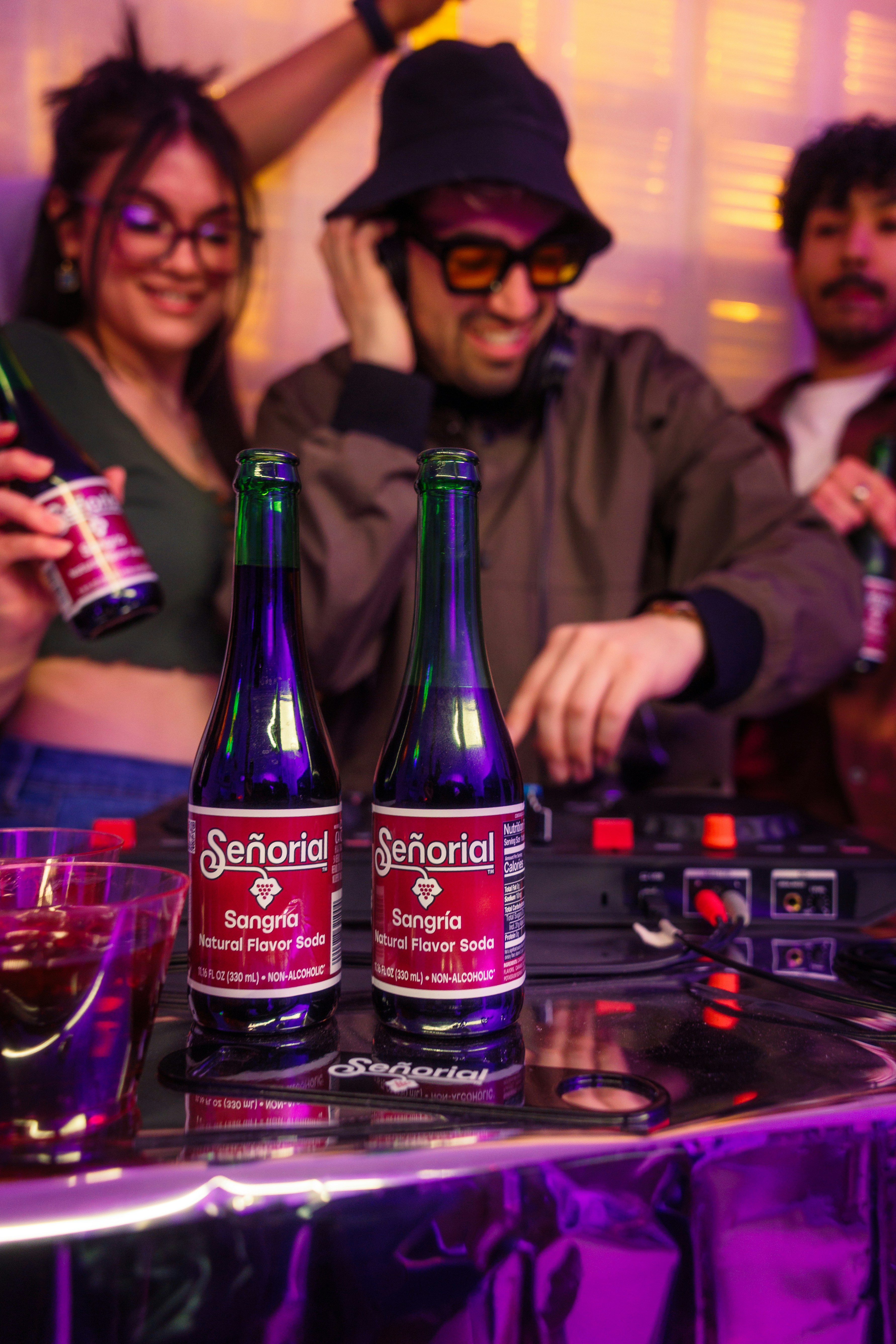 Friends enjoy drinks at a party with a dj.