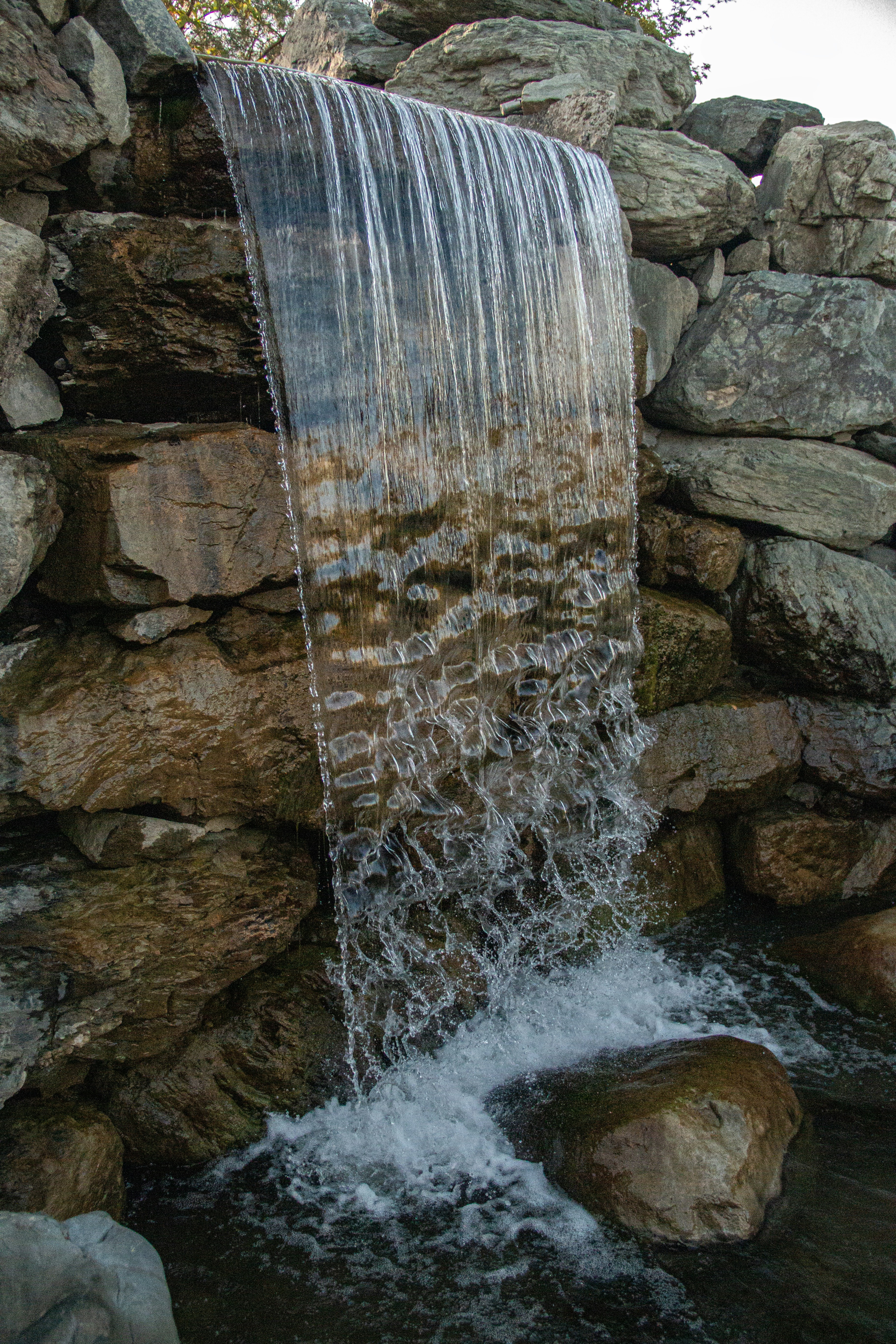Waterfall cascading over rocks, creating a beautiful scene.