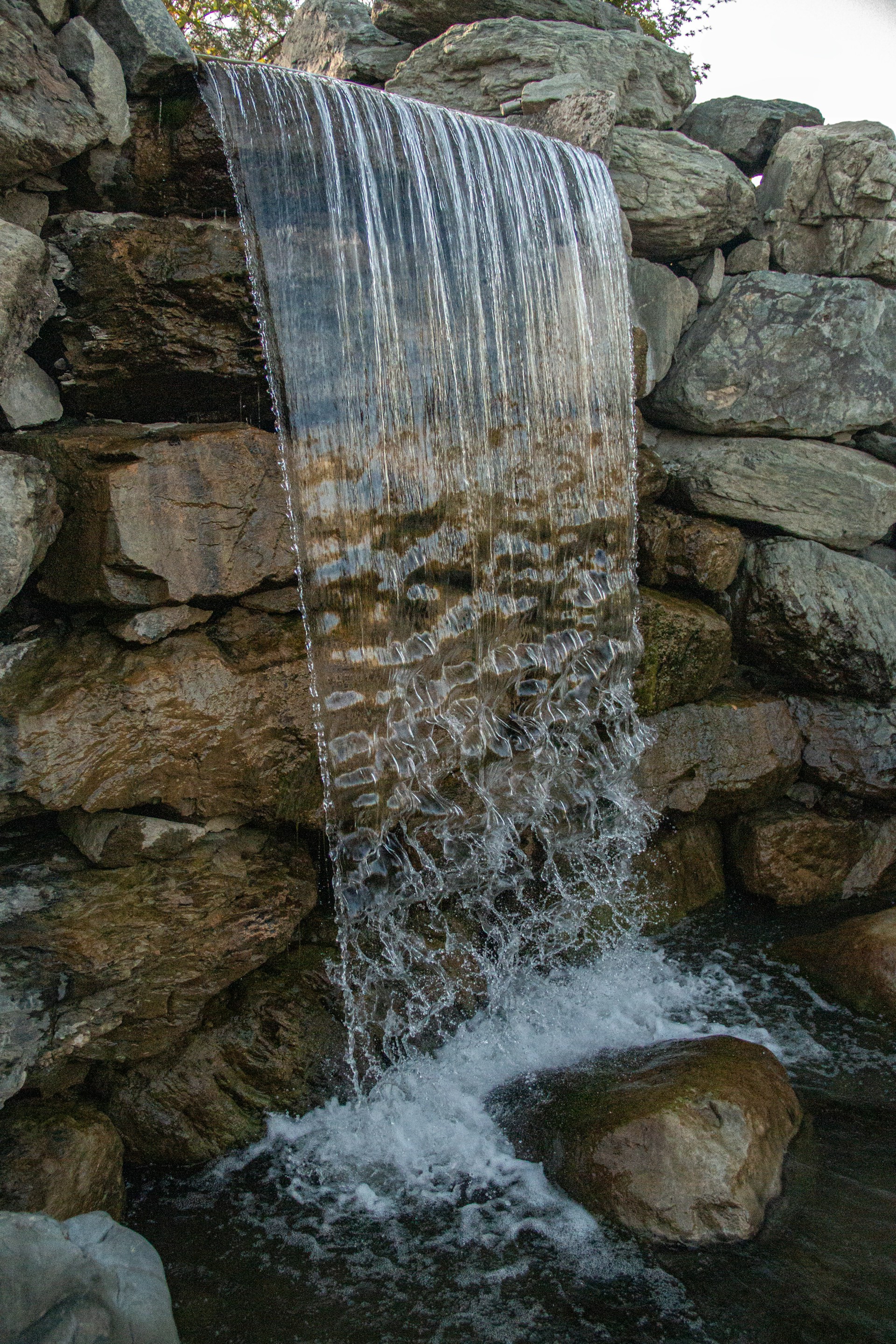 Waterfall cascading over rocks, creating a beautiful scene.