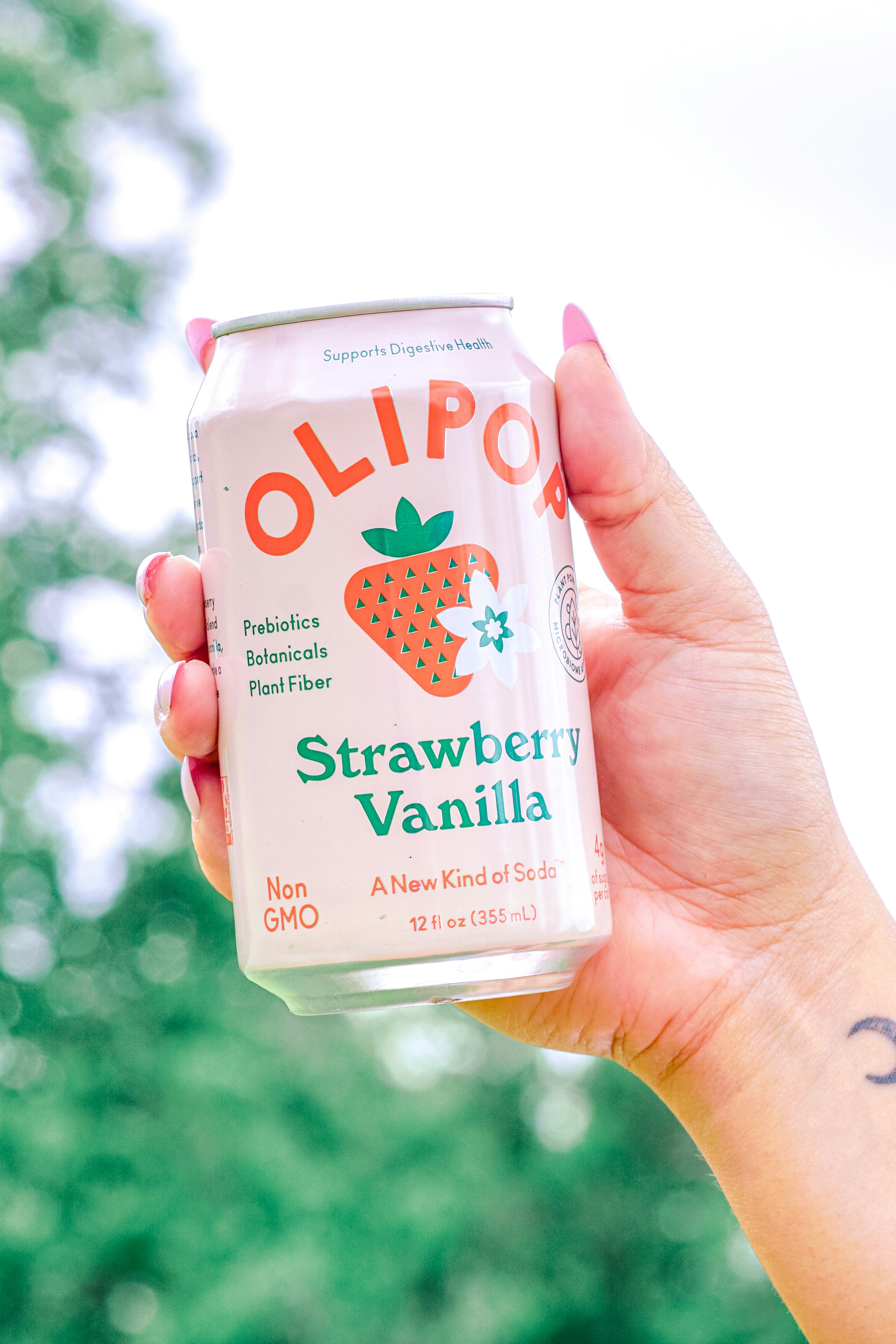 La donna tiene in mano una lattina di olipop alla vaniglia alla fragola.