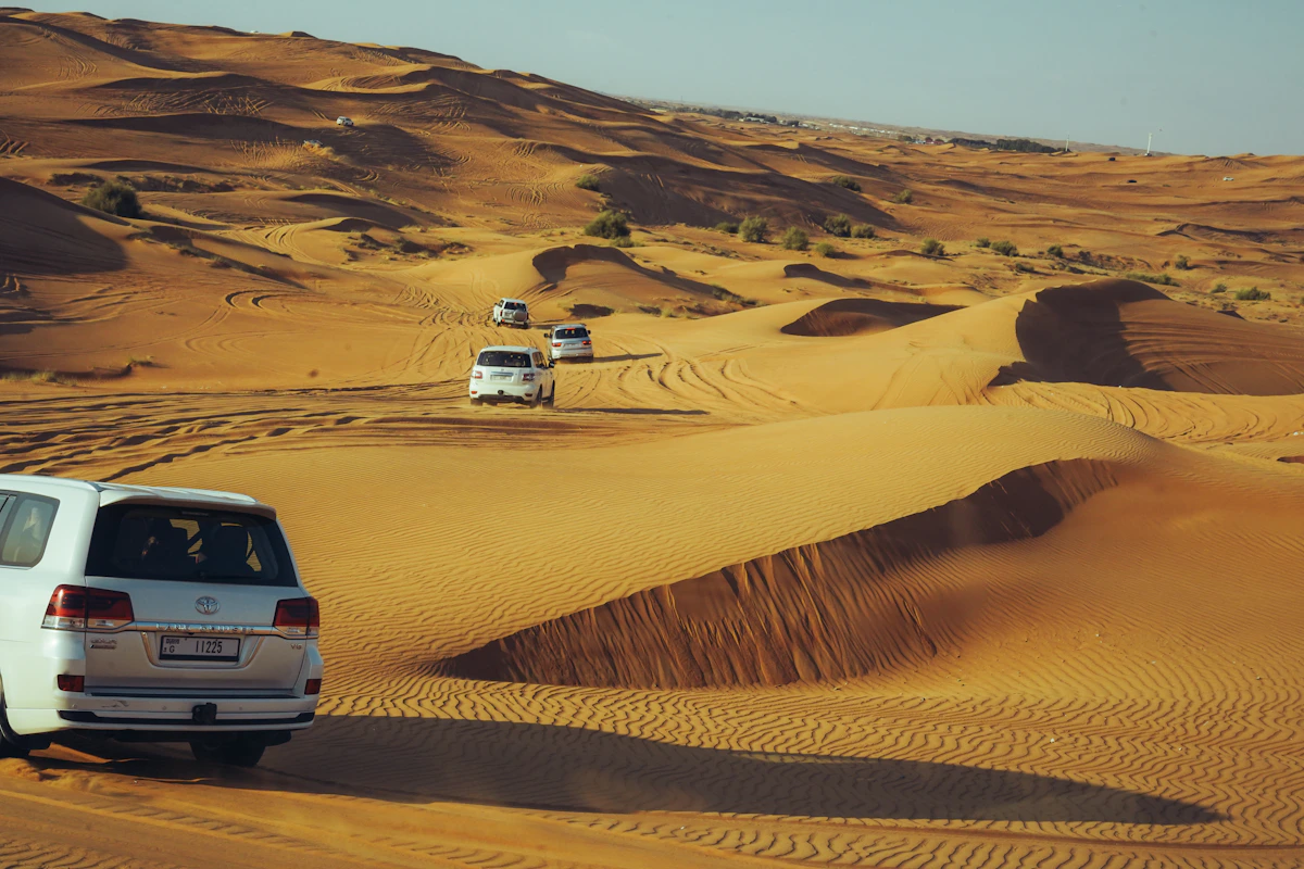 Off-road vehicles crossing Dubai desert dunes