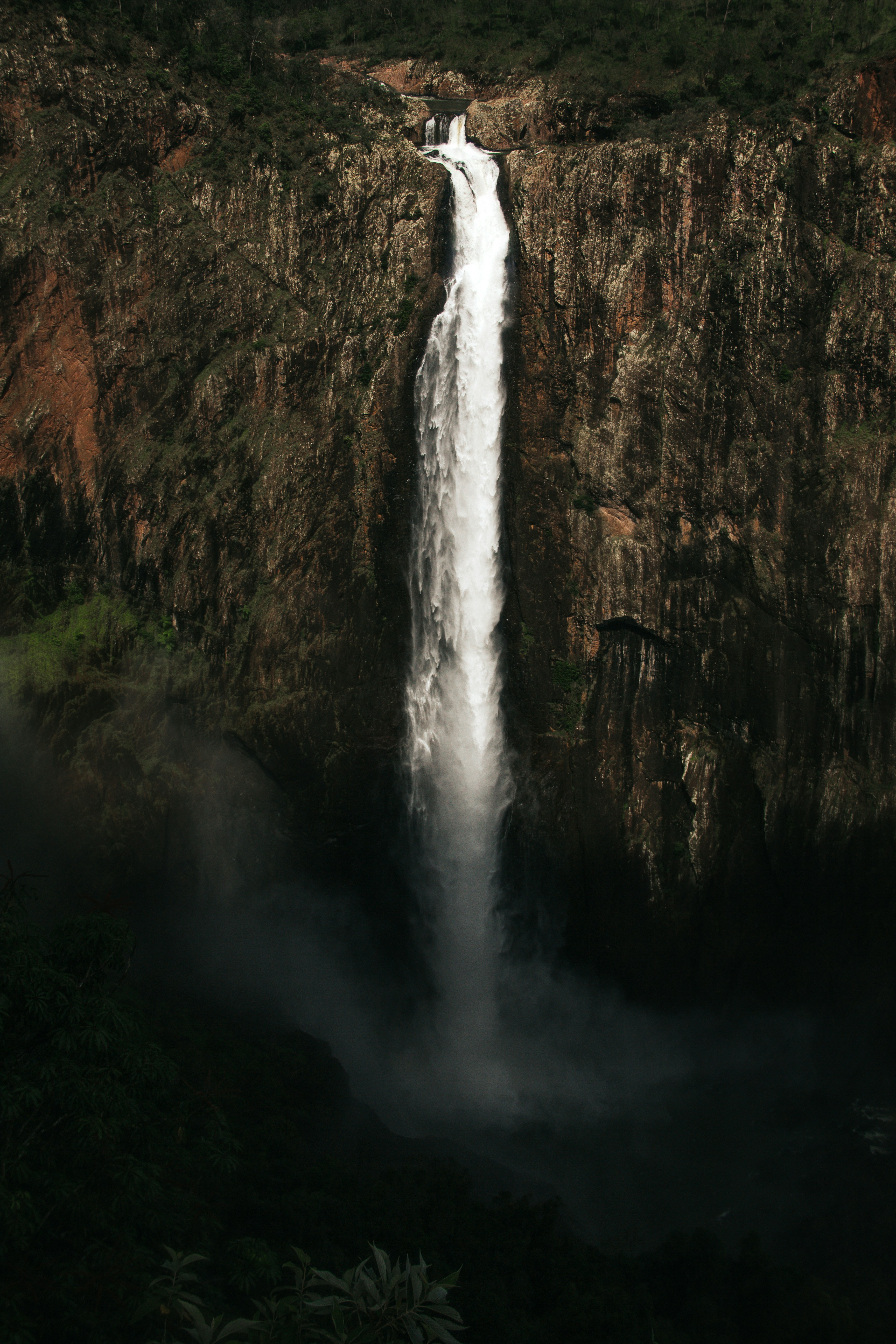 A tall waterfall cascades down a rocky cliff.