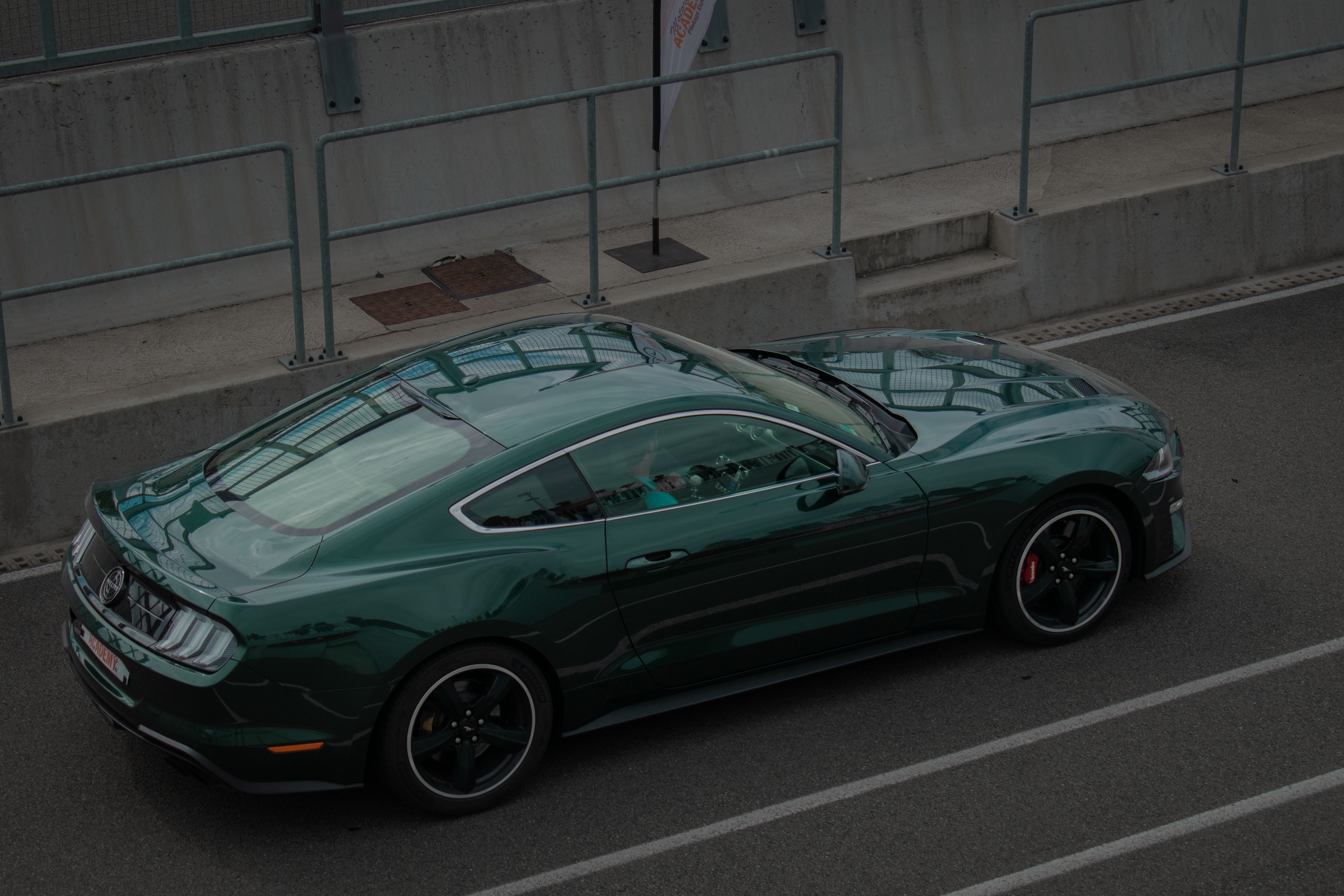 A green ford mustang is shown on a track.