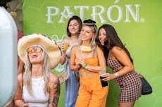 Friends pose happily in a photo booth with props.