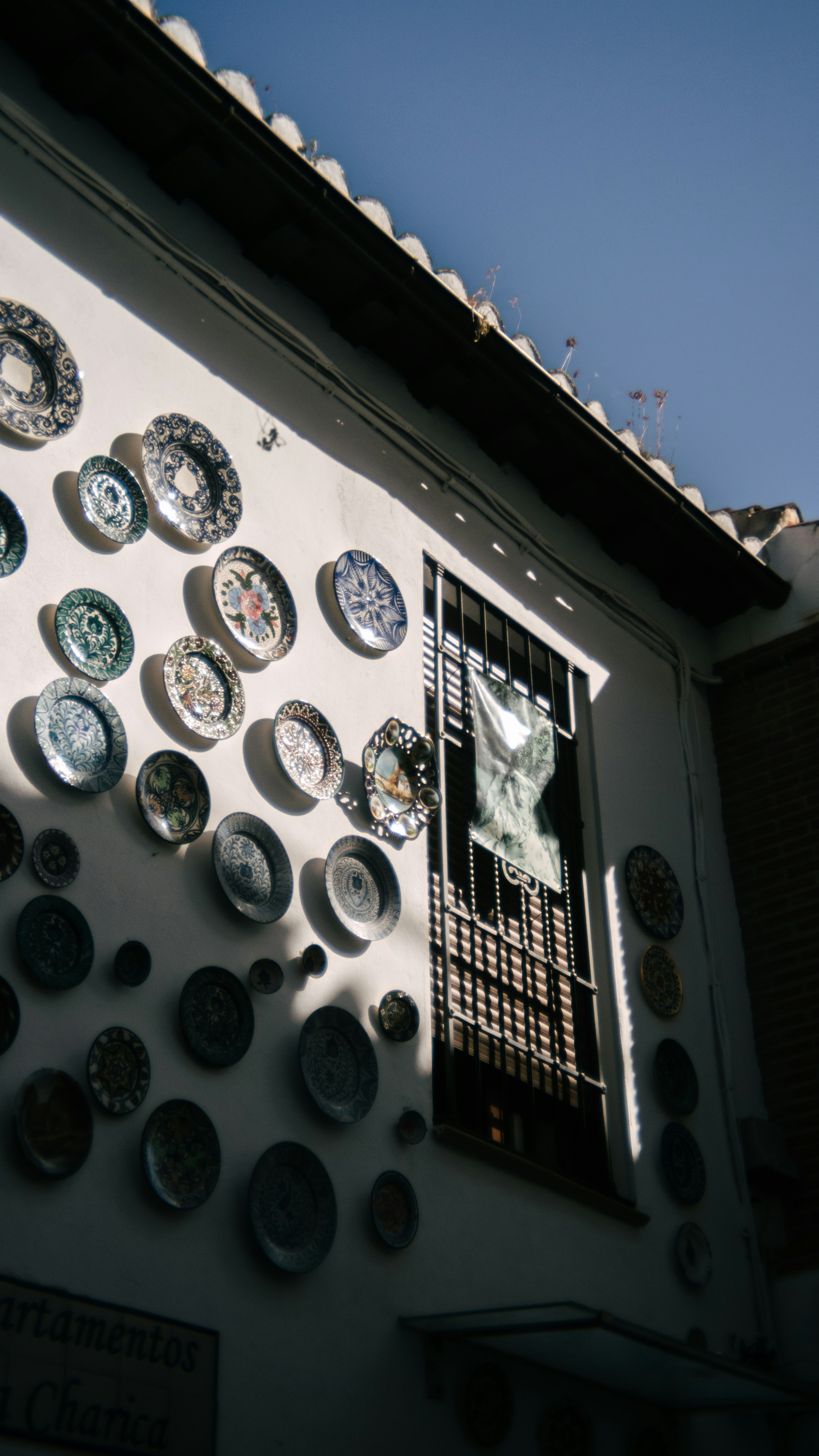 Plates adorn a white building facade.