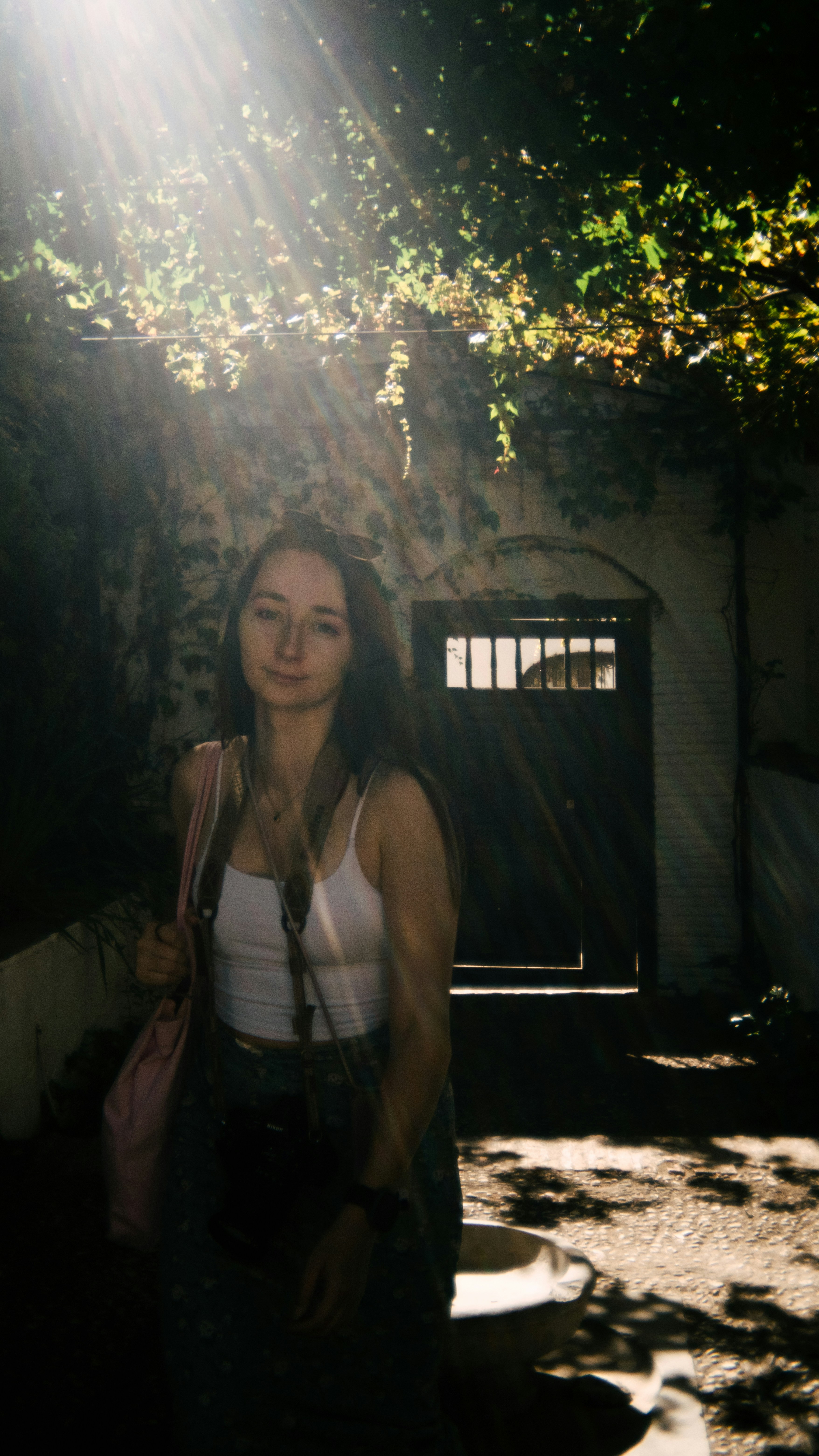 A young woman stands in sunlight.
