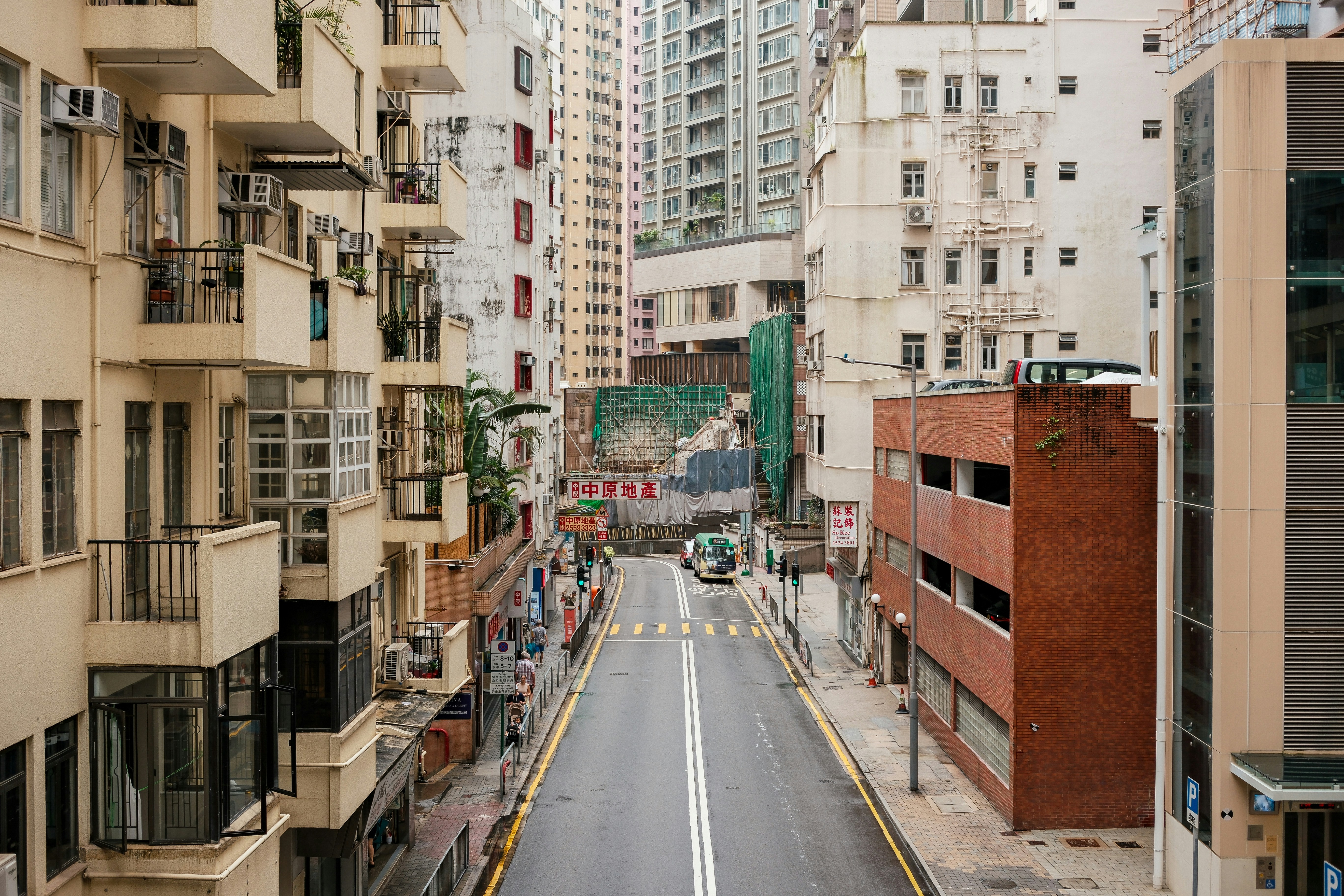 A narrow city street is lined with tall buildings.