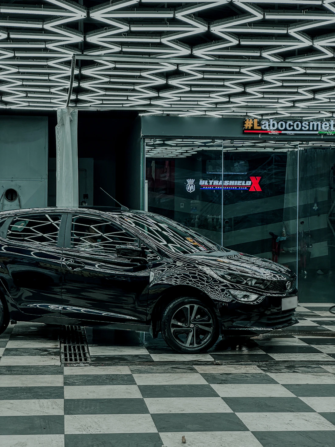 Polished black car in a modern detailing studio