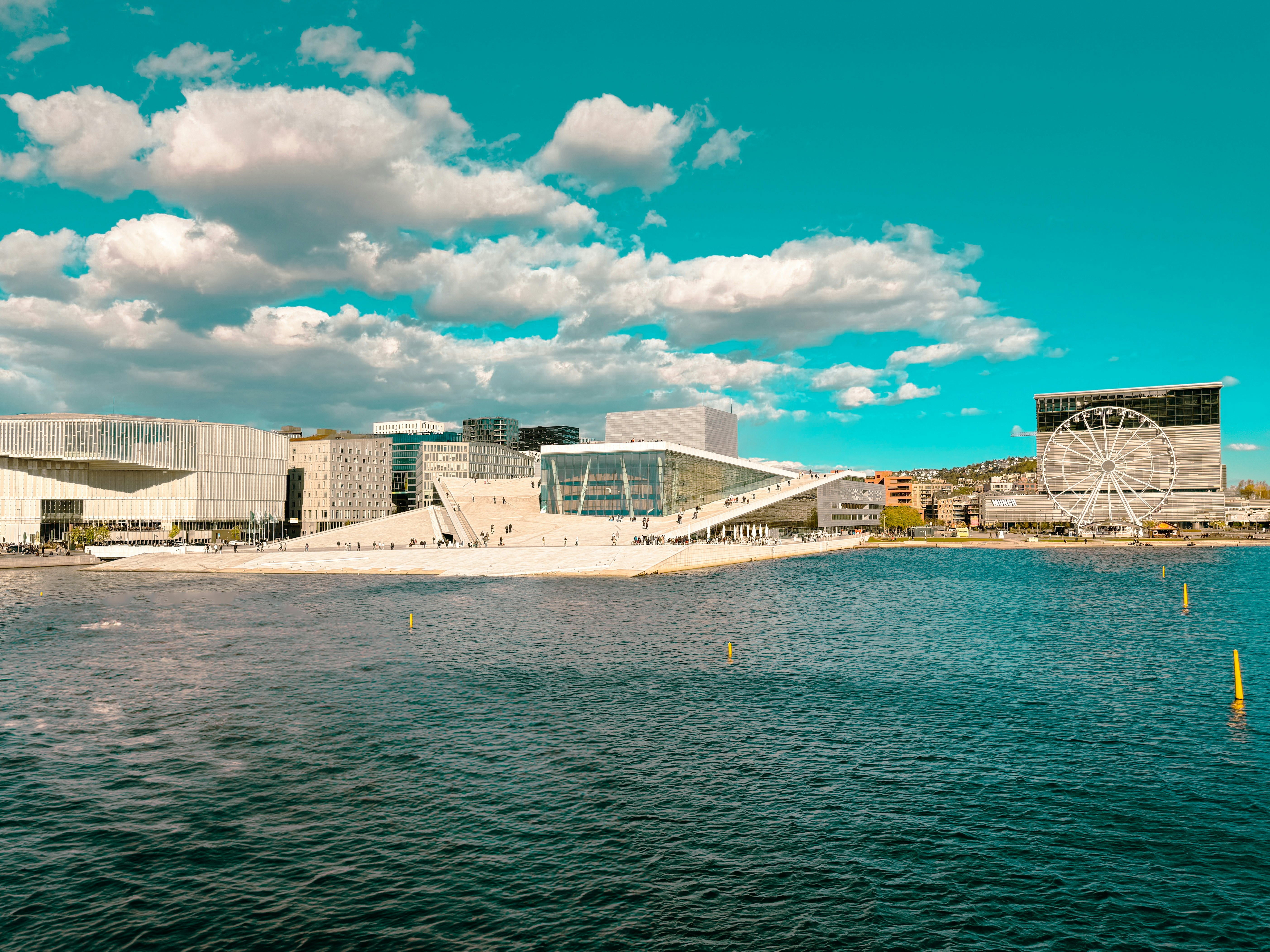 Modern architecture sits on a waterfront, under a blue sky.