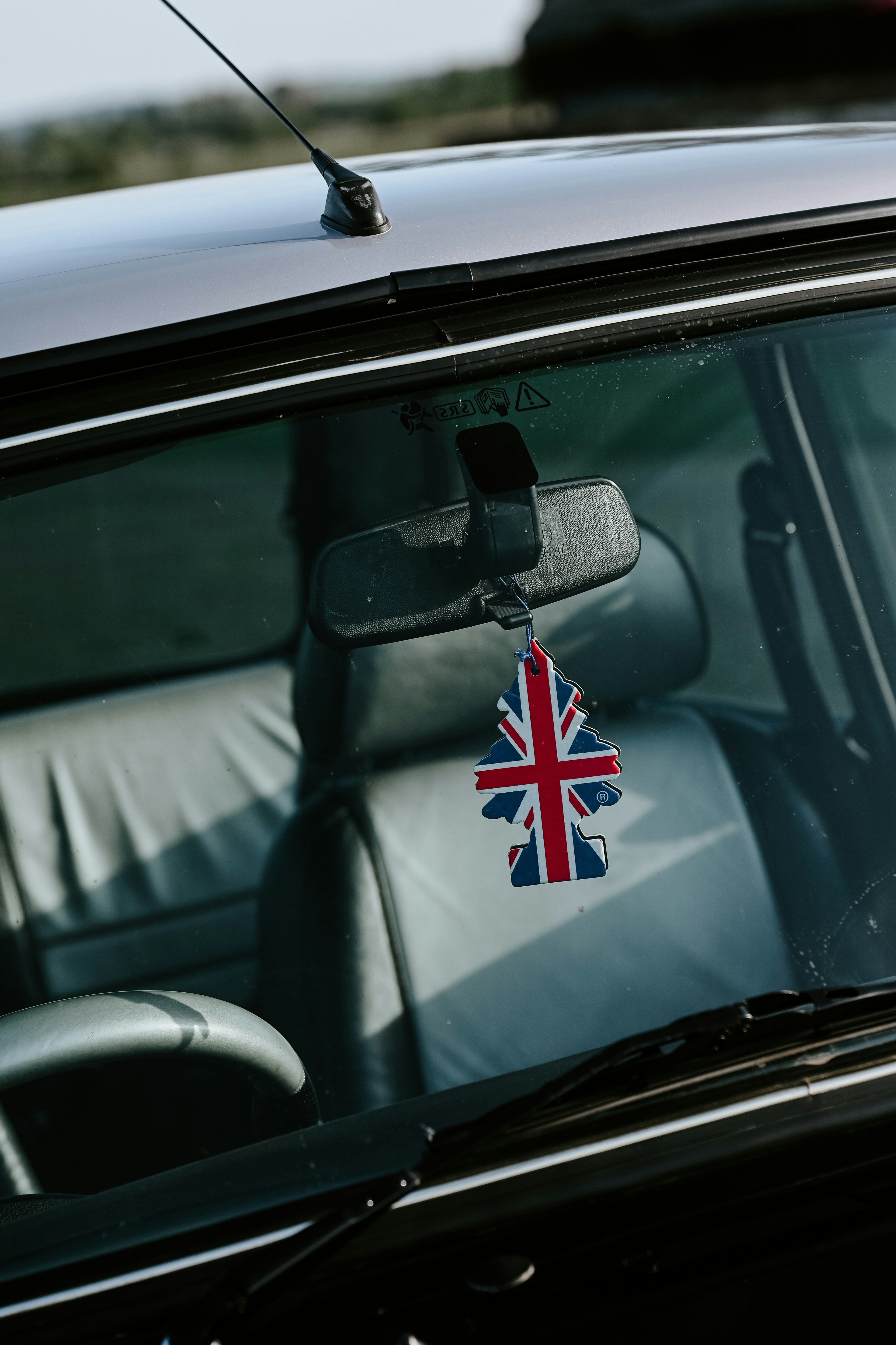 A car's interior with a british flag air freshener.