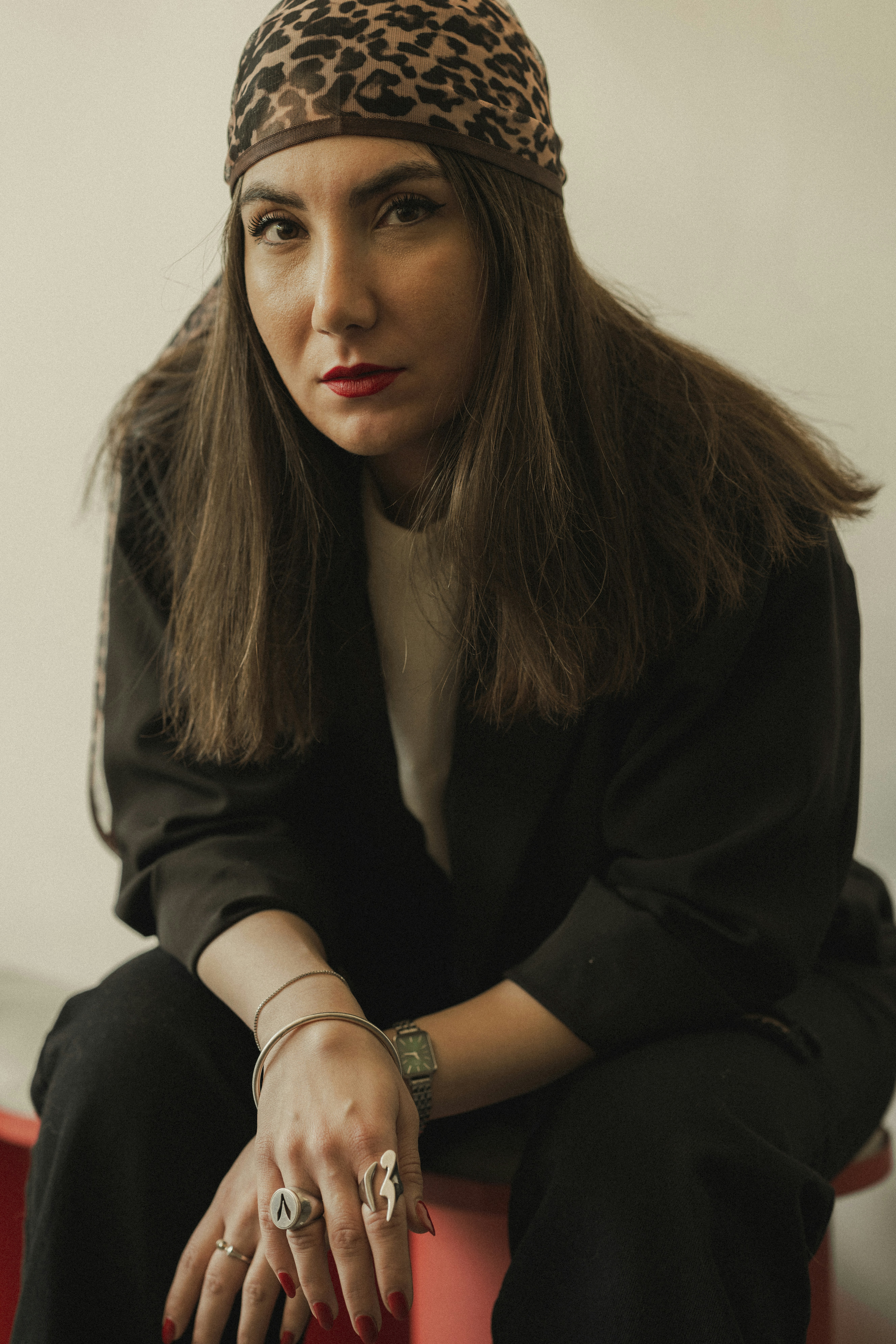 Woman with a scarf and a serious expression.