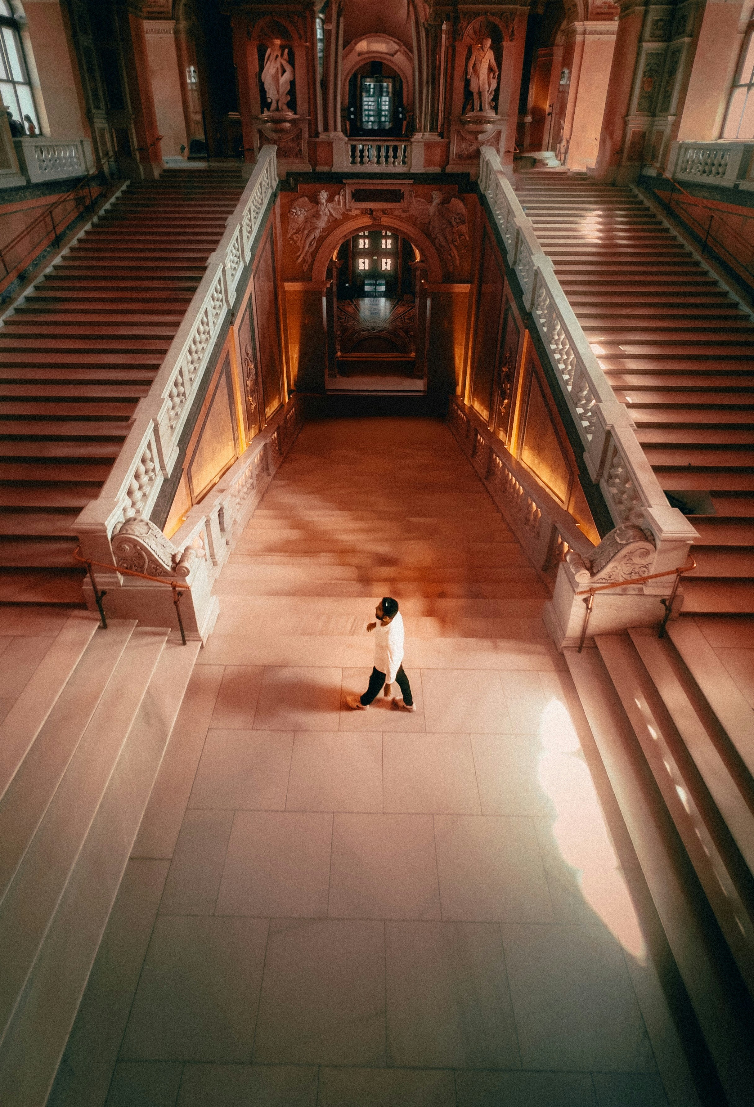 A person walks through a grand hallway.