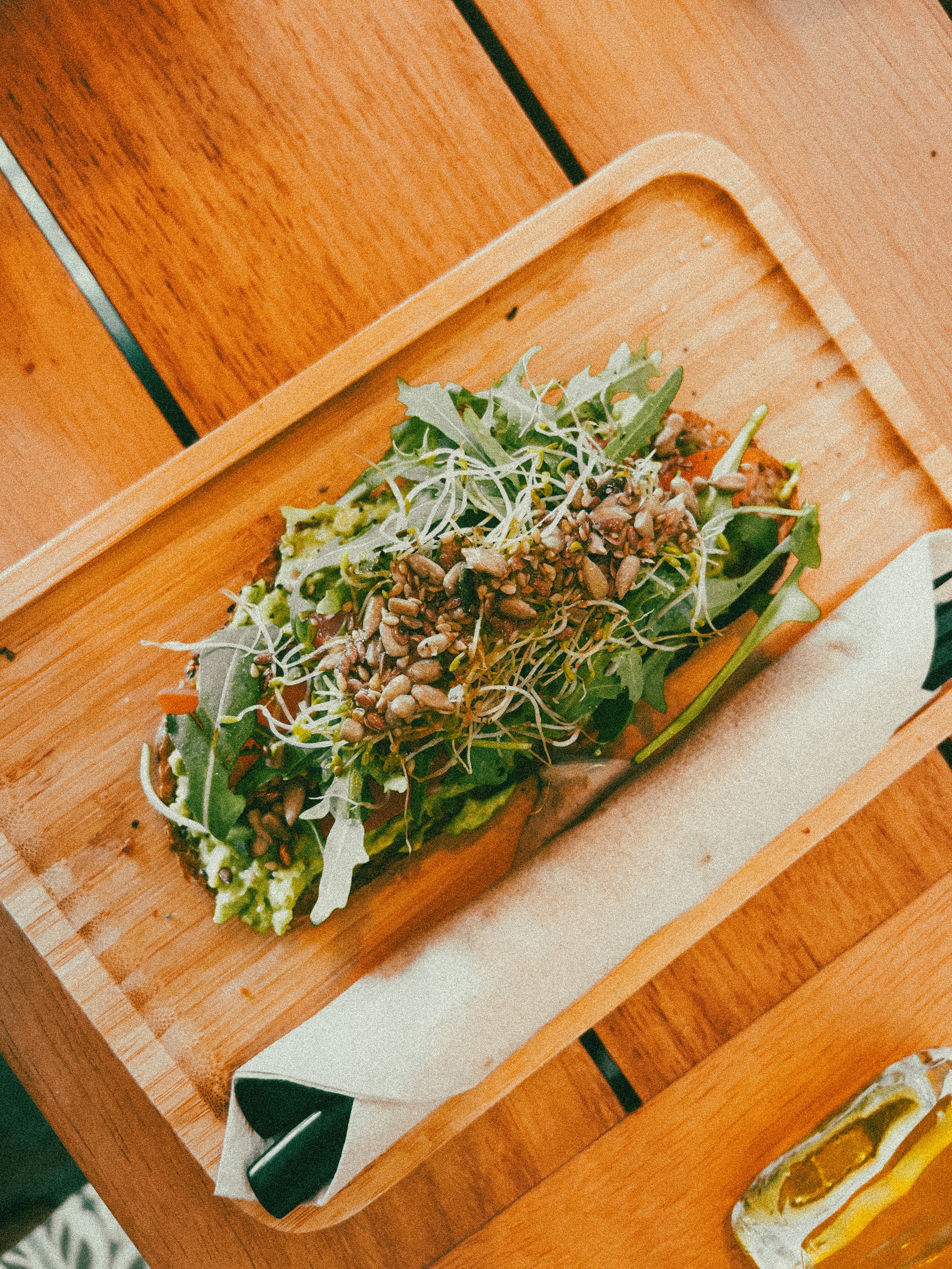 A deliciously healthy wrap is served on a wooden tray.