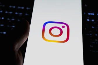 Instagram's logo is displayed on a phone.