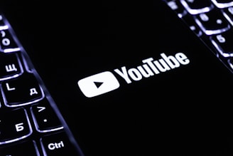 The youtube logo on a smartphone is visible.