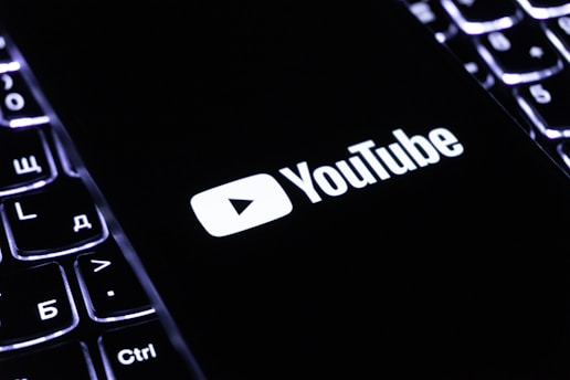 The youtube logo on a smartphone is visible.