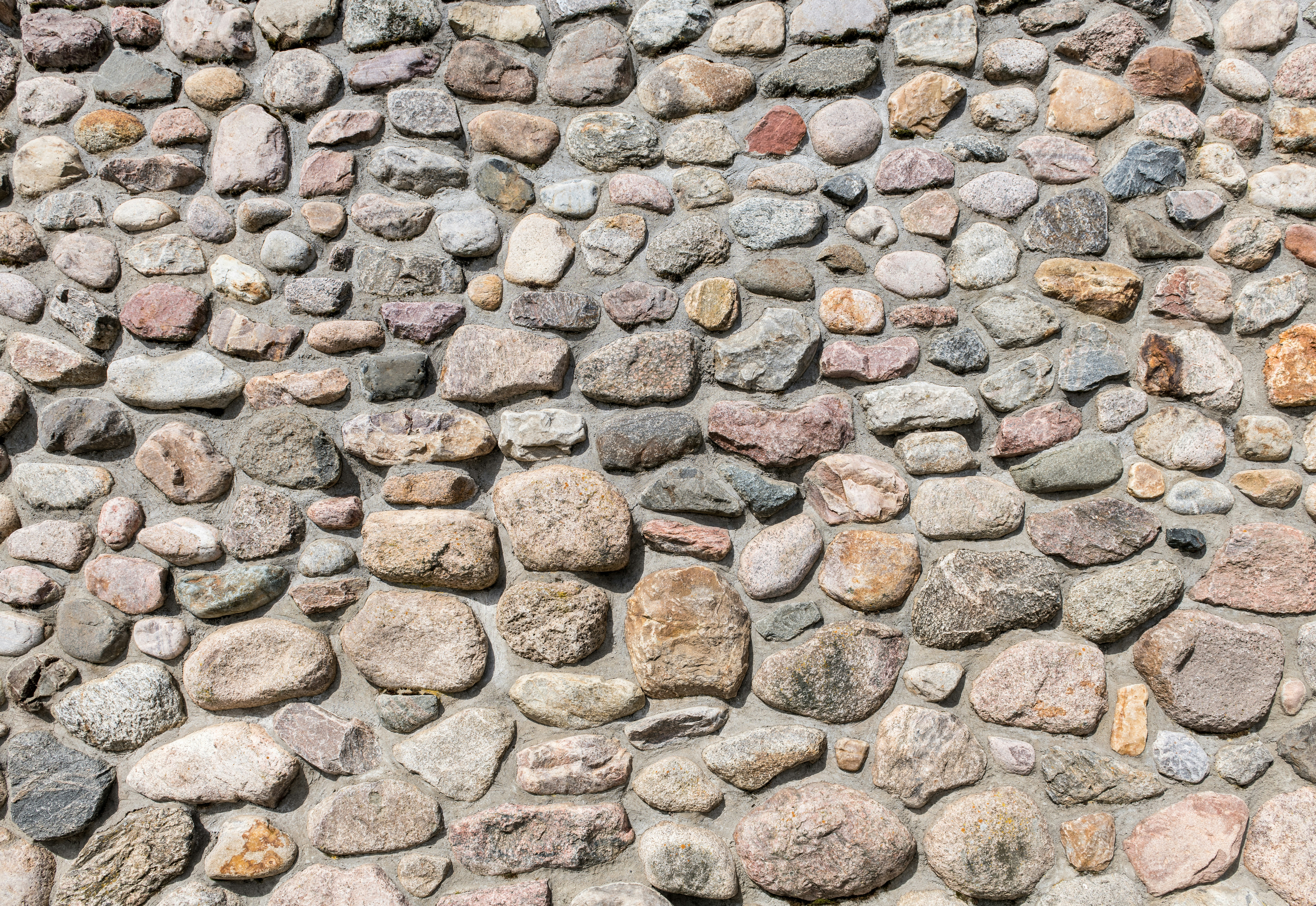 A wall is constructed of various-sized stones.