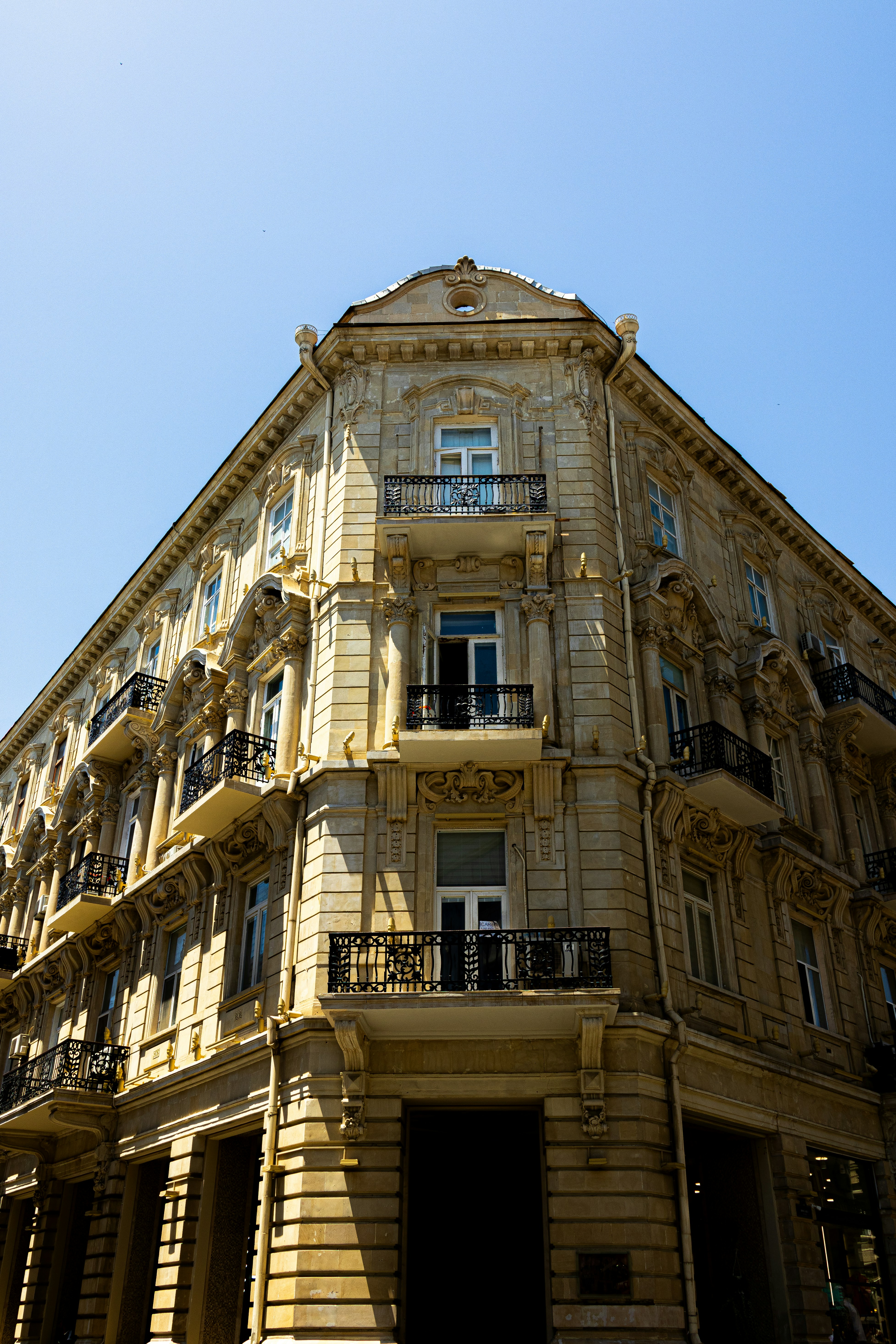 Ornate building with balconies against a blue sky.