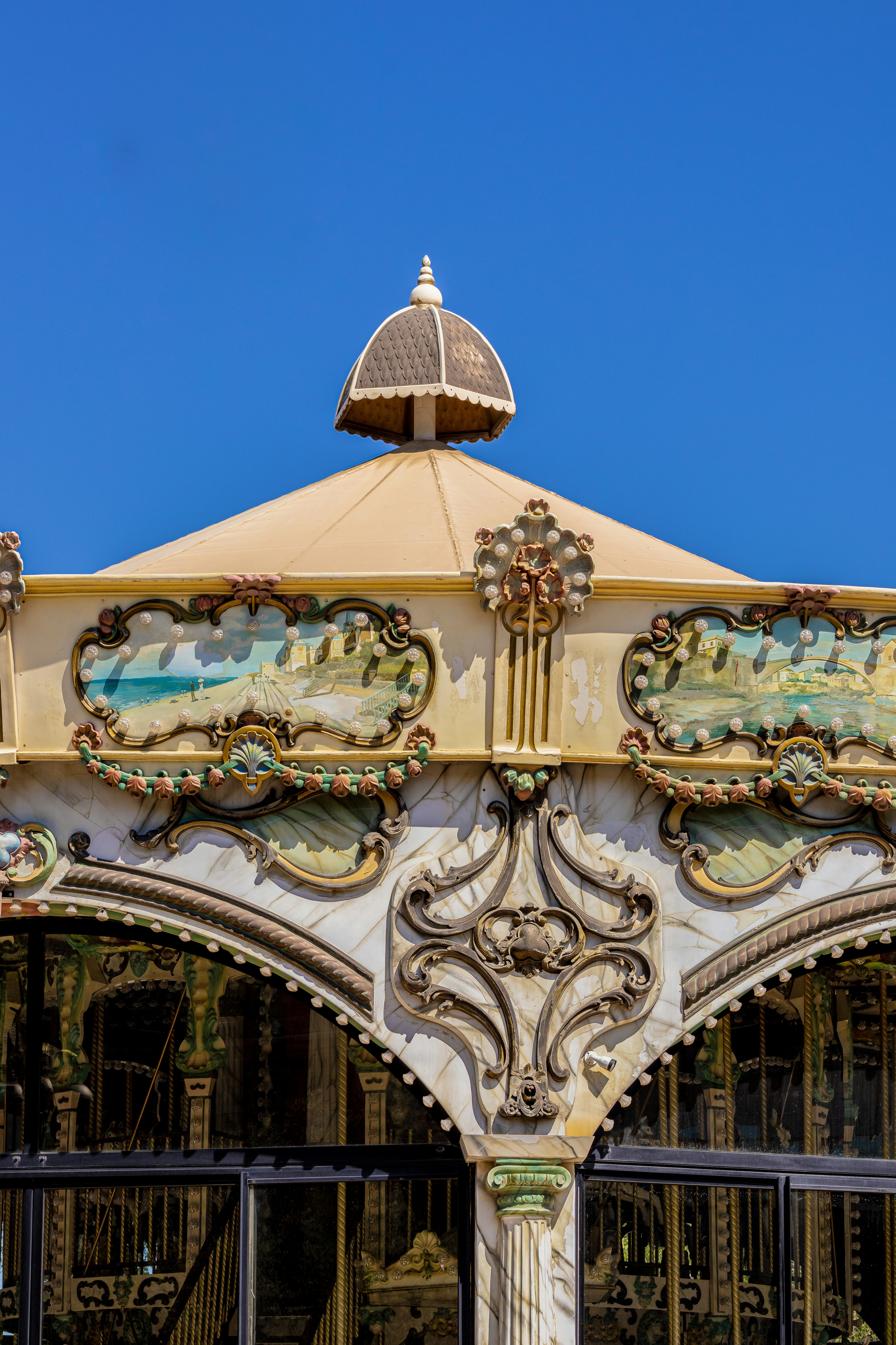 A carousel roof is showcased against a bright blue sky.