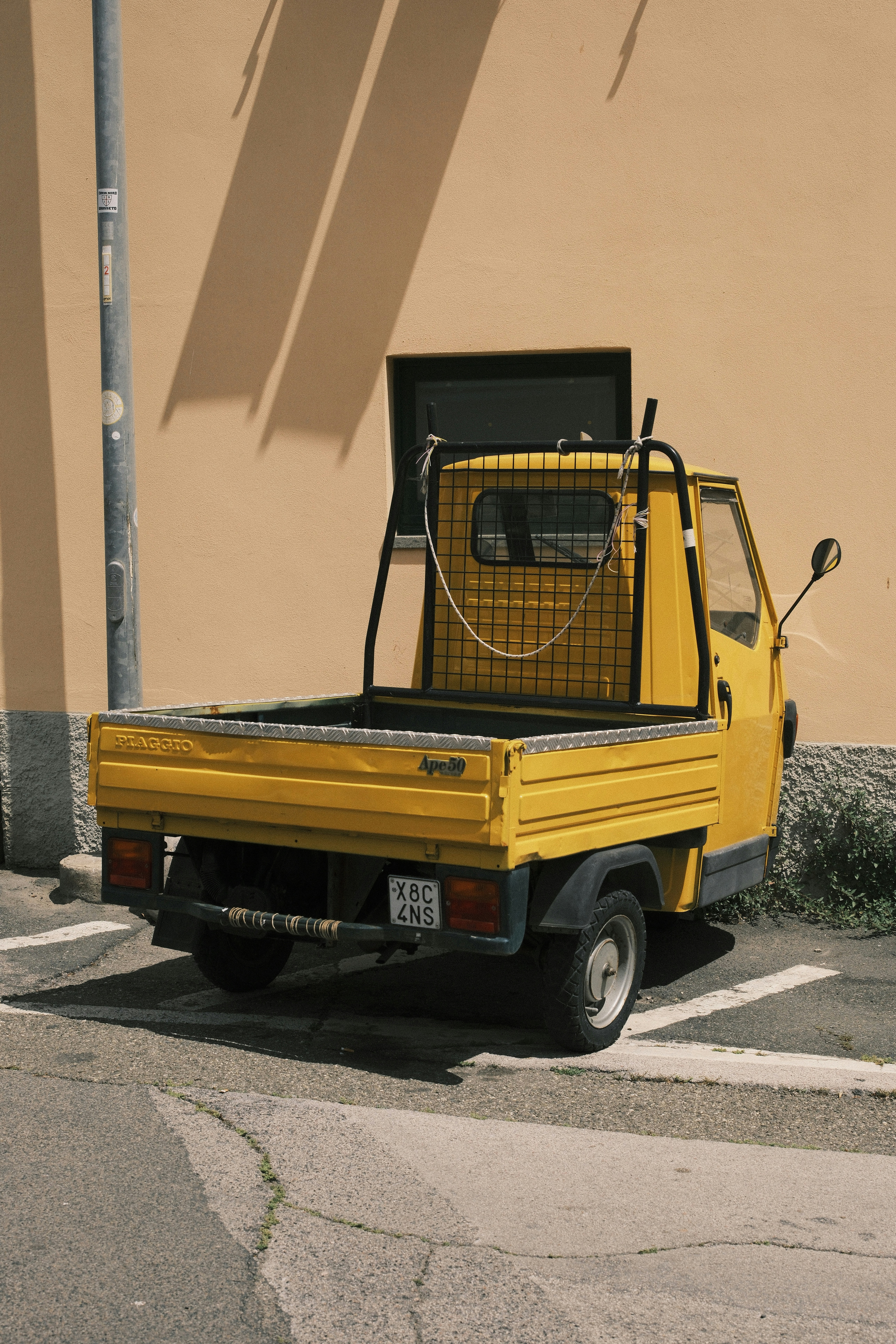 A yellow truck is parked against a wall.