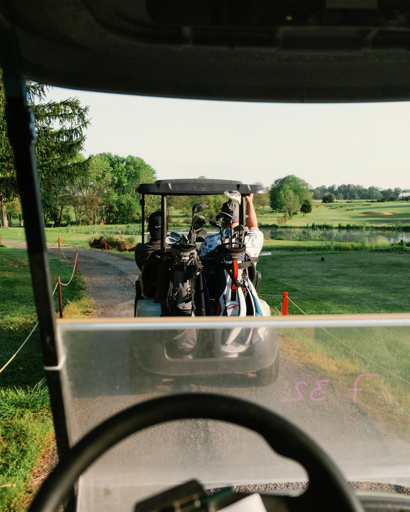 Golf cart heading down a sunny fairway