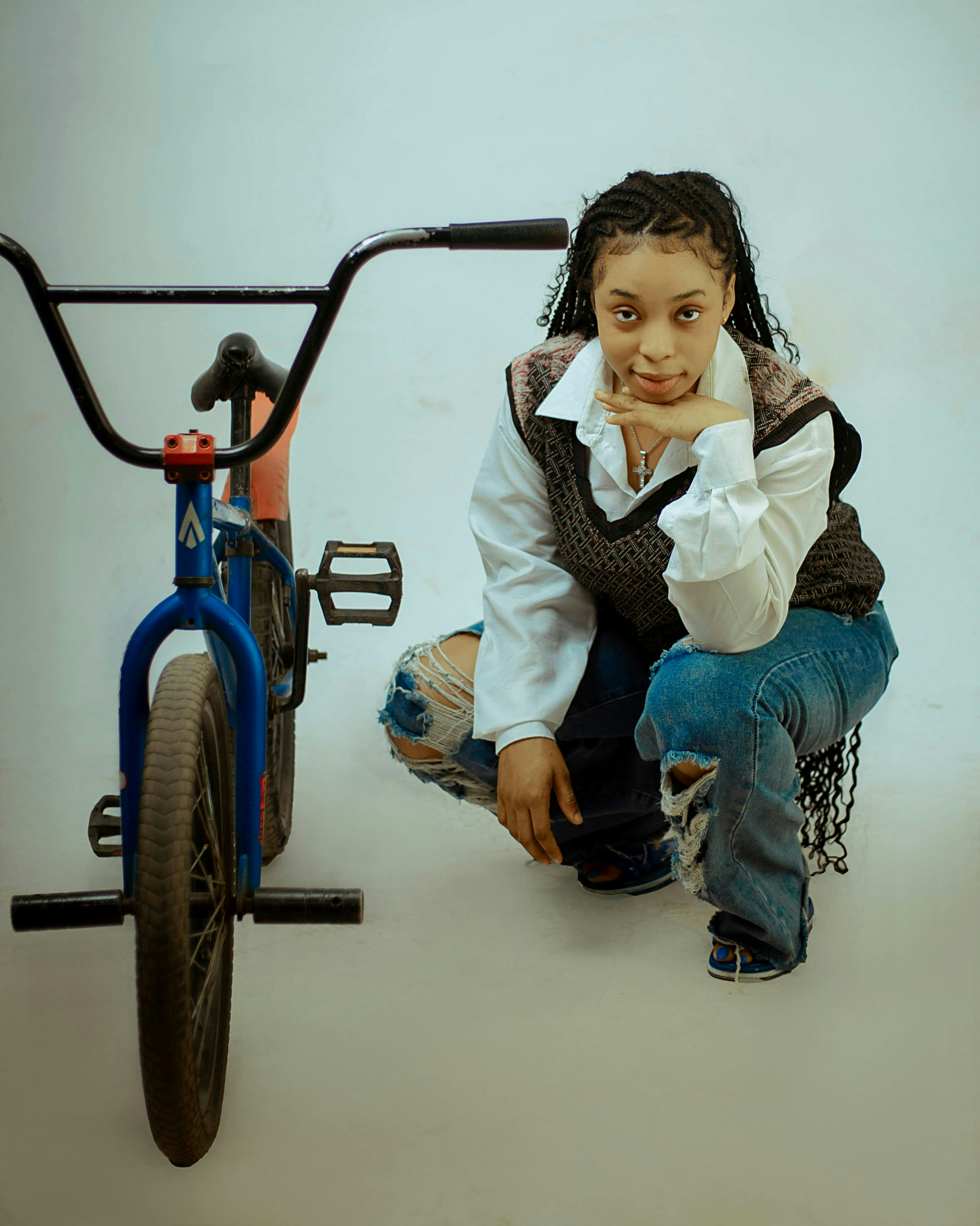 A person poses next to a bicycle.