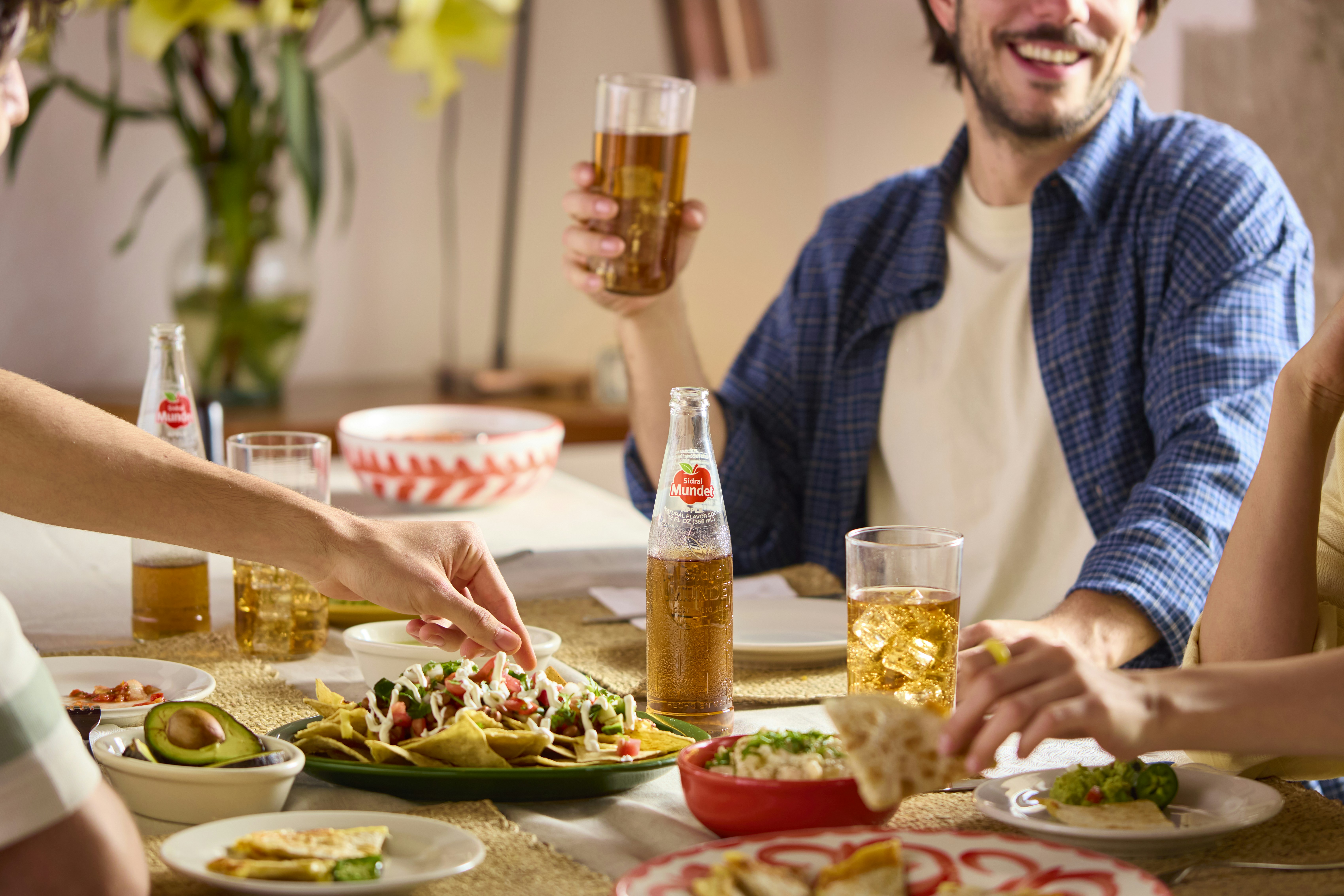 Friends enjoy a meal with beer and mexican food.