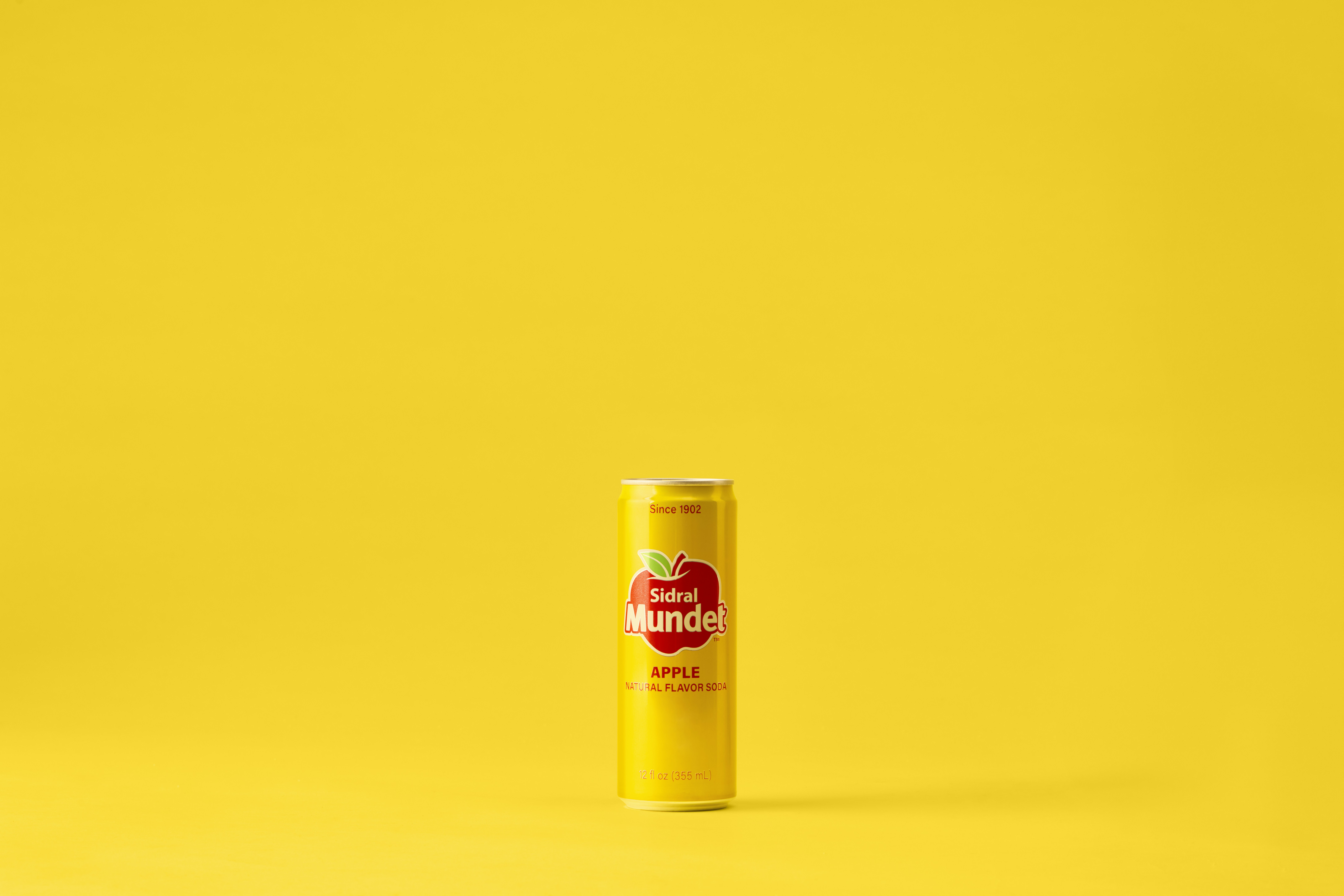A yellow can of apple juice sits.